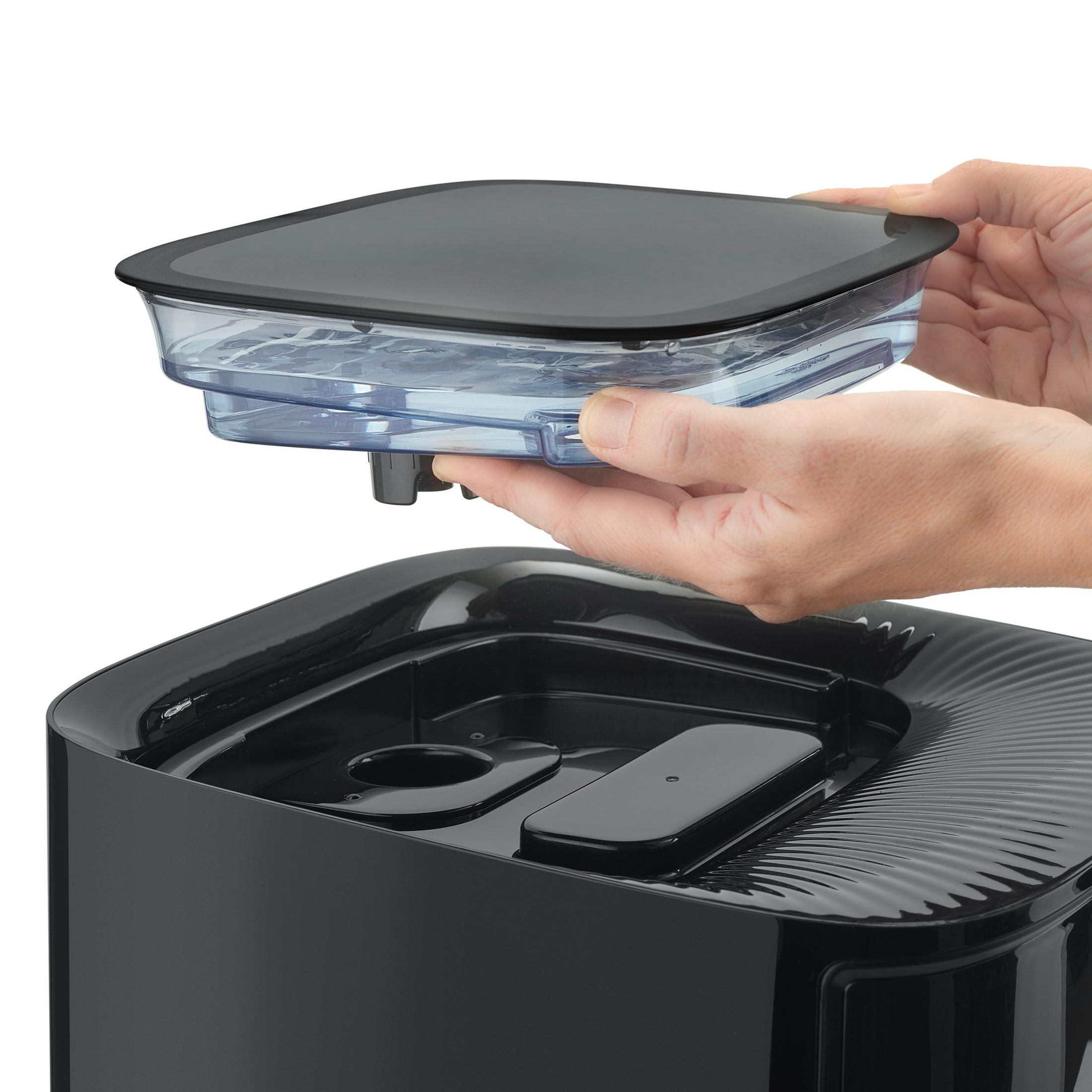 Mani che tengono un contenitore trasparente rimosso da una base nera.