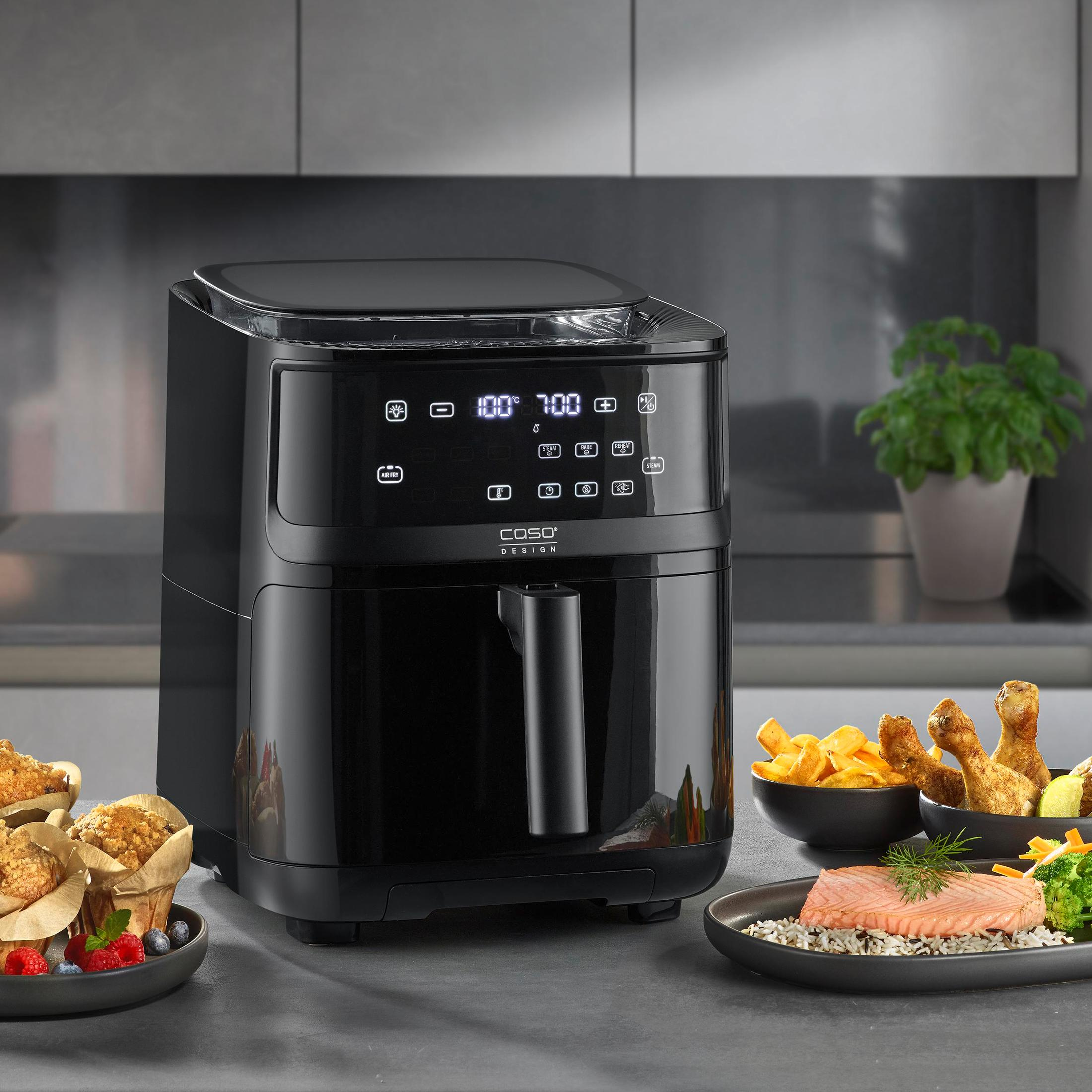 Friggitrice ad aria nera con cibo. Cibi fritti e altri piatti sono nell'inquadratura.