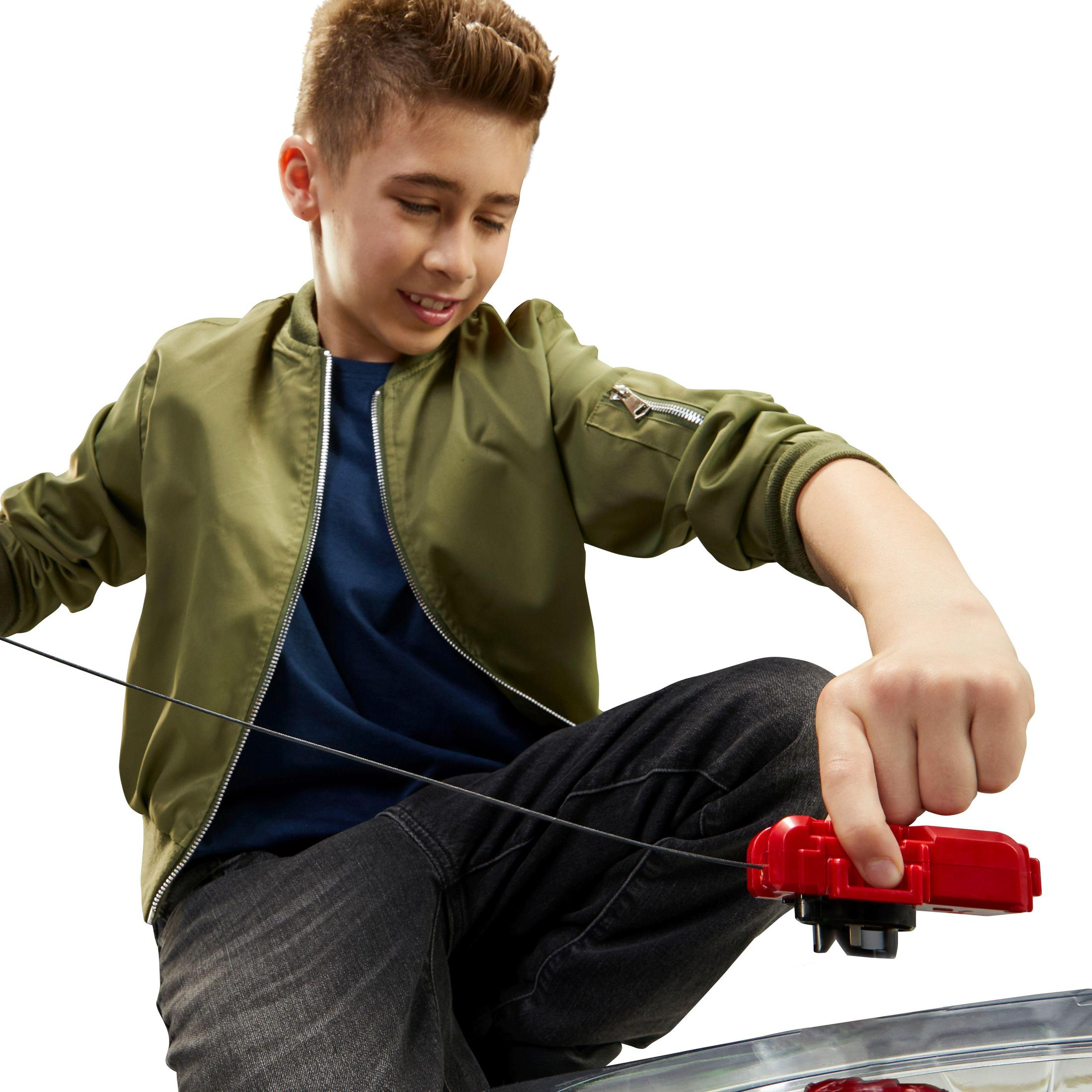 Een jongen speelt met een rood speeltje. Het is een spel met een touwtje.