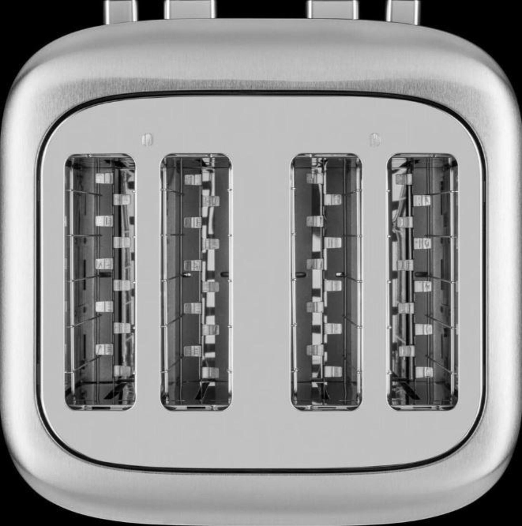 Nahaufnahme eines silbernen Toasters mit vier Schlitzen. Reflektierende Oberflächen und dunkles Inneres sichtbar.