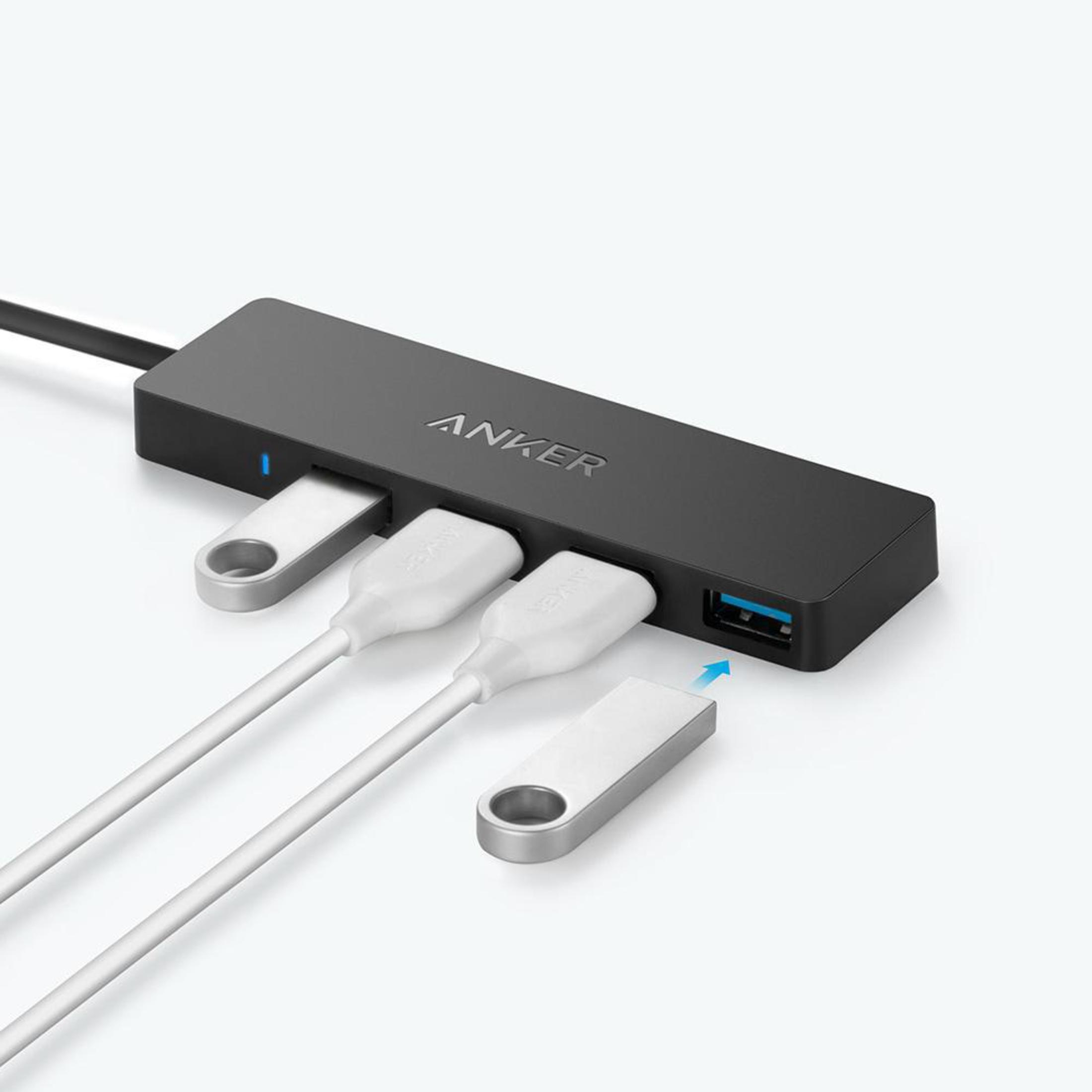 Un hub USB Anker nero con porte USB e tre cavi USB collegati.