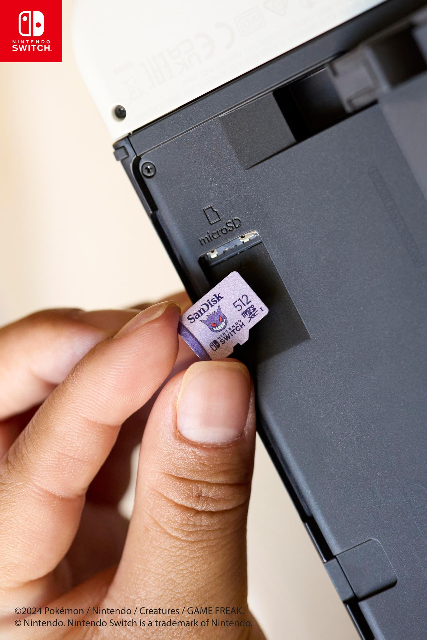Hand steckt microSD-Karte in Nintendo Switch Konsole, Nahaufnahme.