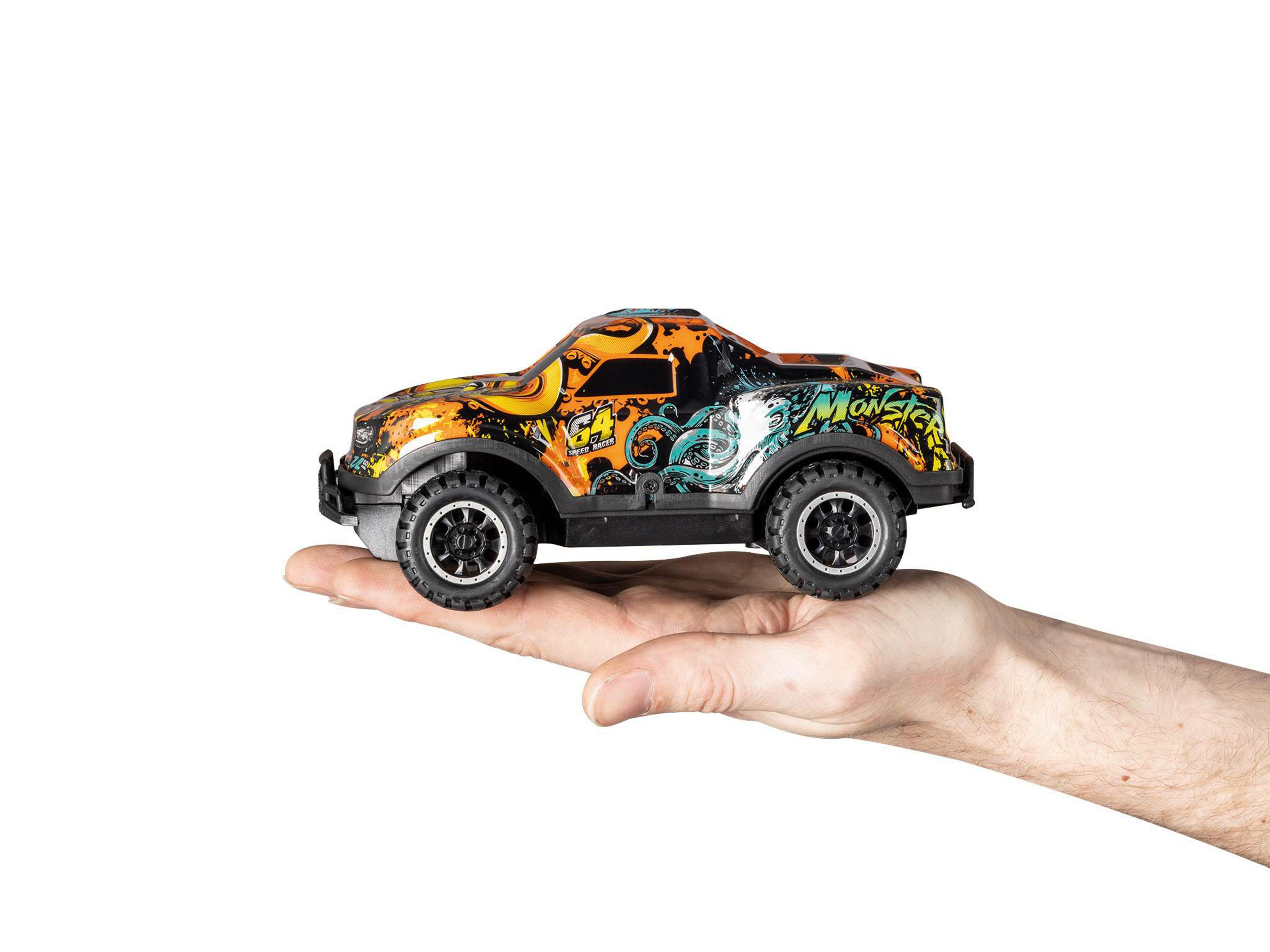 Ein Spielzeug-Monstertruck in einer Hand, vor weißem Hintergrund. Der Truck hat bunte Grafiken.