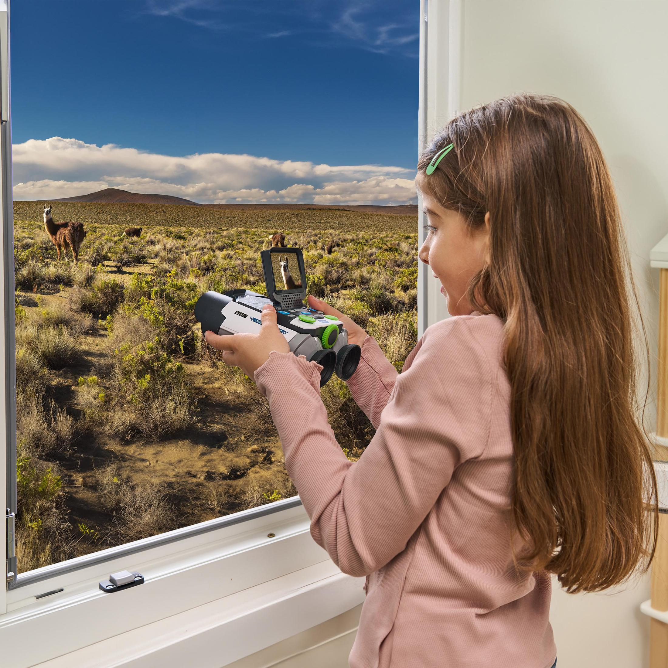Ein Mädchen blickt durch ein Fernglas auf eine malerische Landschaft mit Lamas.