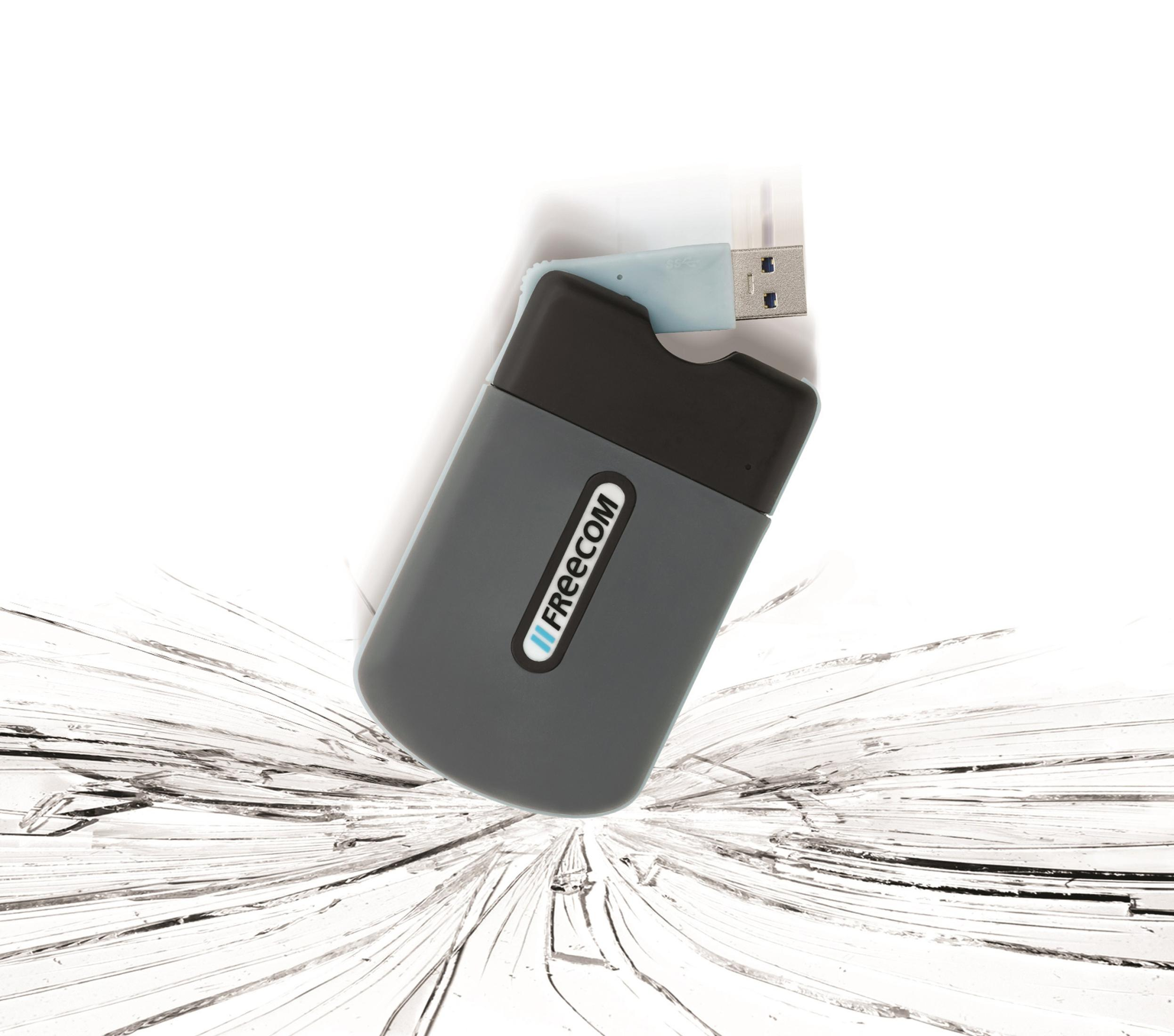 Lettore di schede Freecom grigio con connettore USB, su sfondo di vetro rotto.