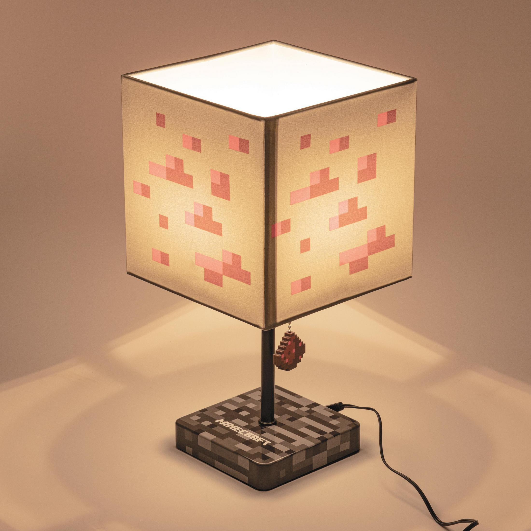 Eine Minecraft-Themenlampe mit einem Würfelschirm und einem Minecraft-Logo-Sockel.