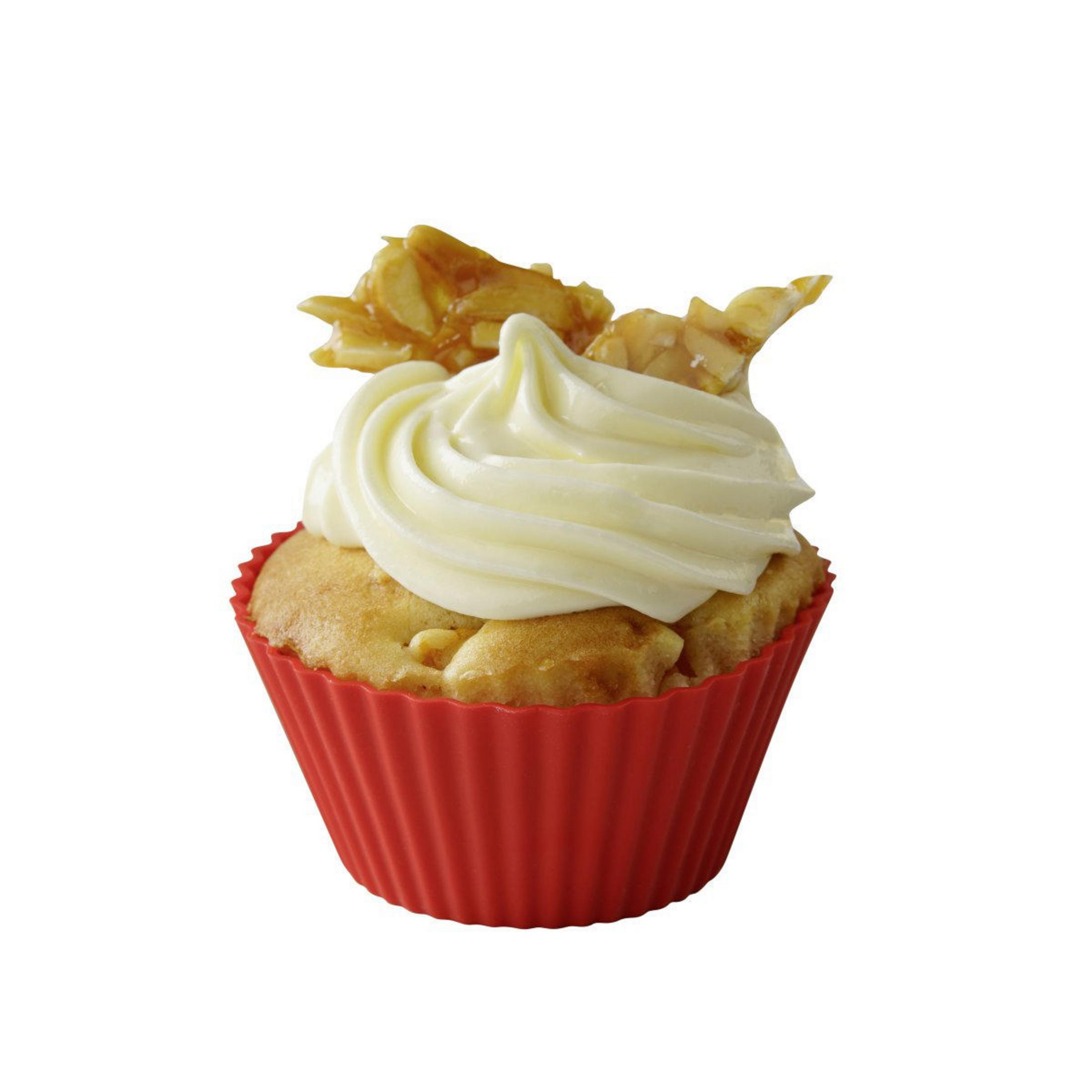 Ein Cupcake in einer roten Papierform, belegt mit weißem Zuckerguss und Süßigkeiten.