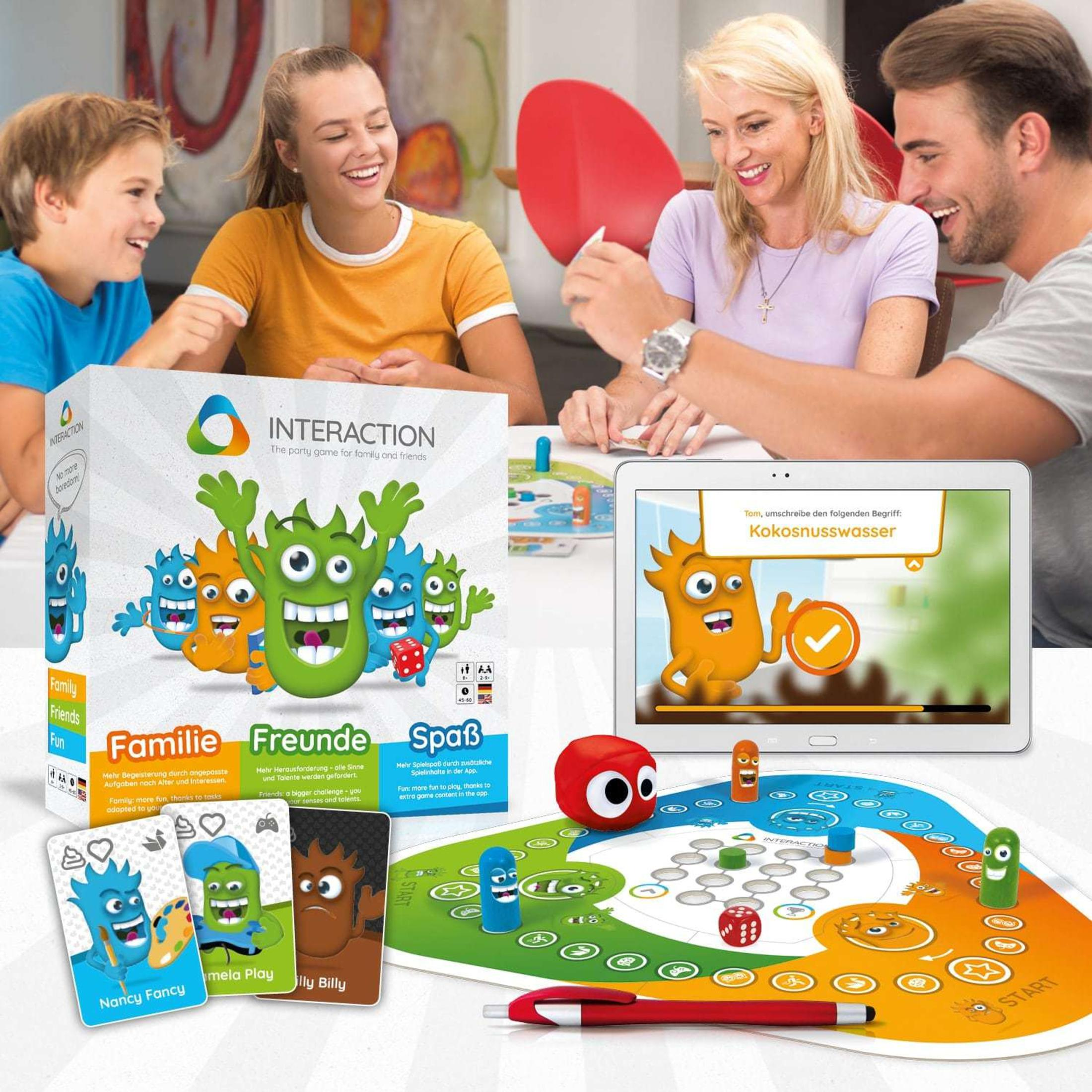 Eine Familie spielt ein Brettspiel. Ein Tablet zeigt einen Cartoon eines Monsters.