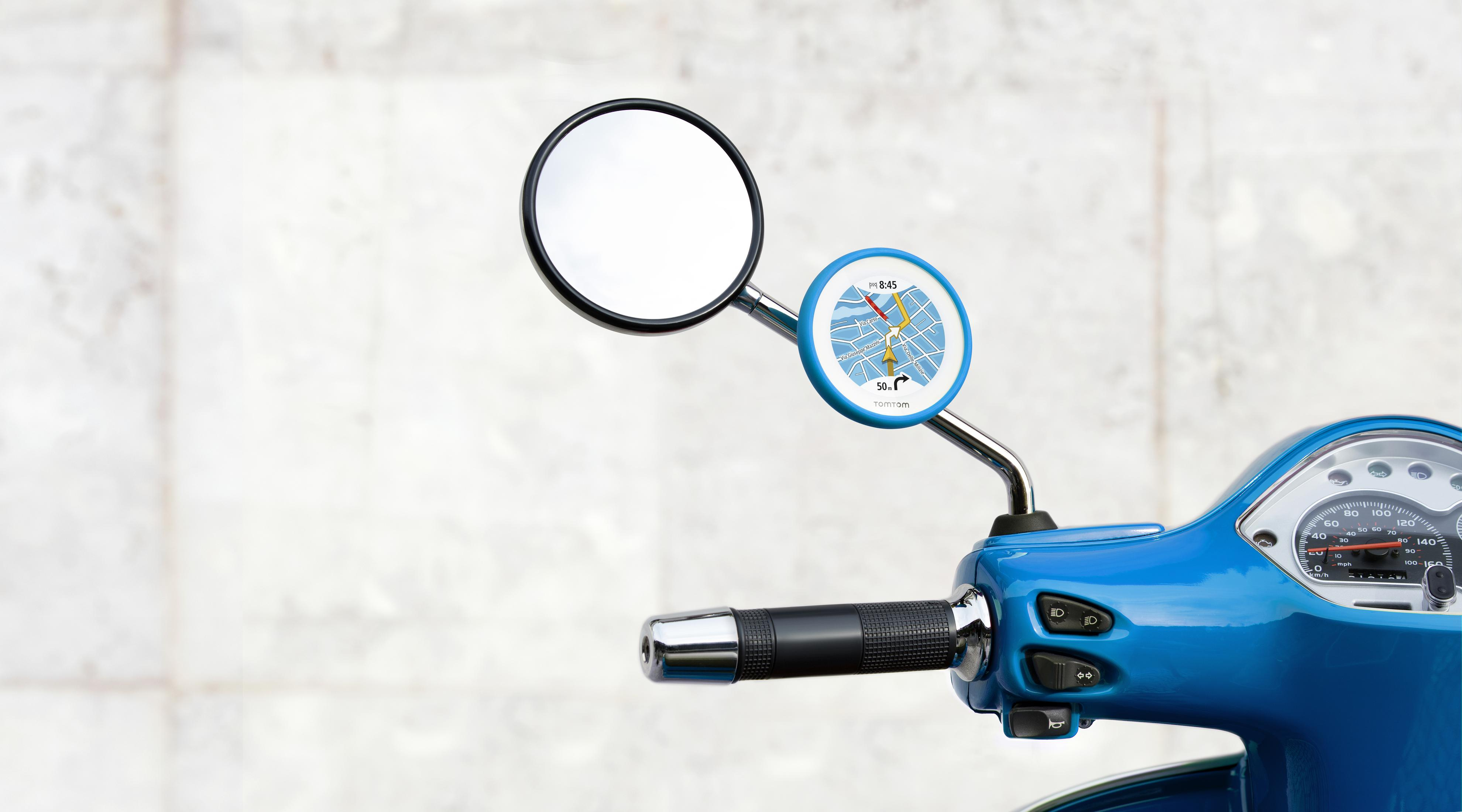 Lusterko skutera z ekranem nawigacji. Skuter jest niebieski. Tło jest jasnoszare.