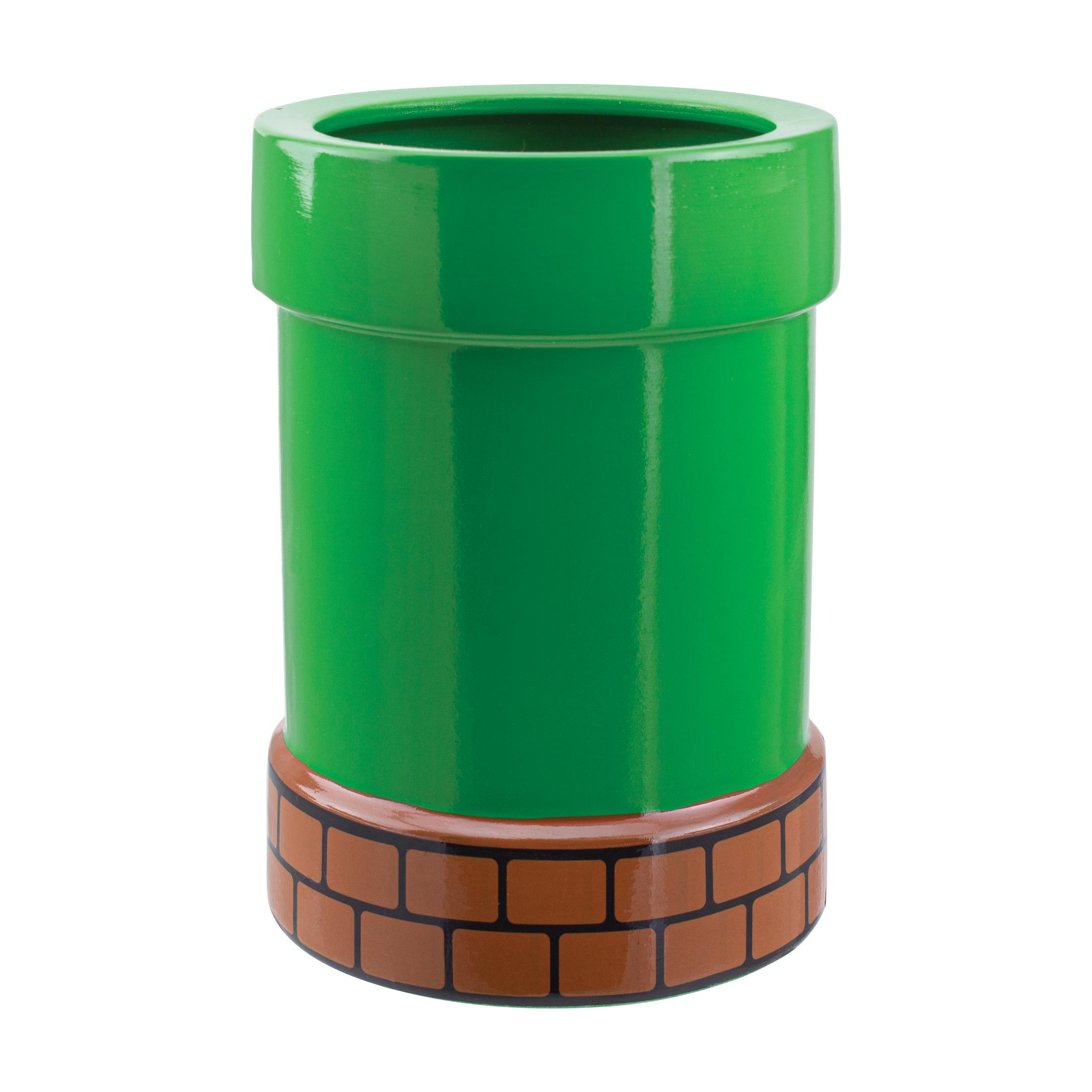 Grünes zylindrisches Mario-Rohrspielzeug auf weißer Oberfläche. Der Boden hat ein Ziegelmuster.