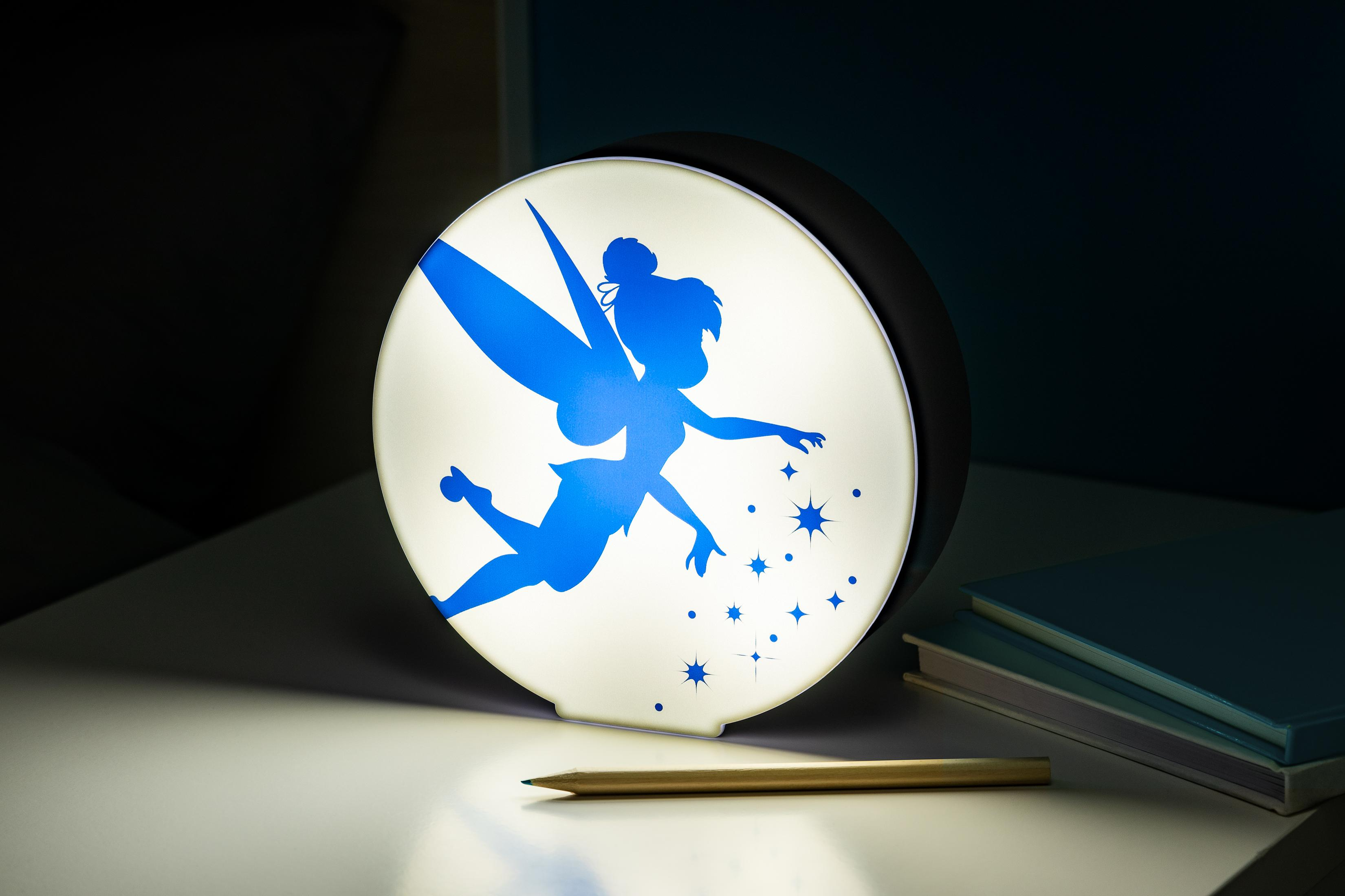 Ein Tinkerbell-Nachtlicht auf einem Tisch. Es hat eine blaue Tinkerbell-Silhouette und Sterne.