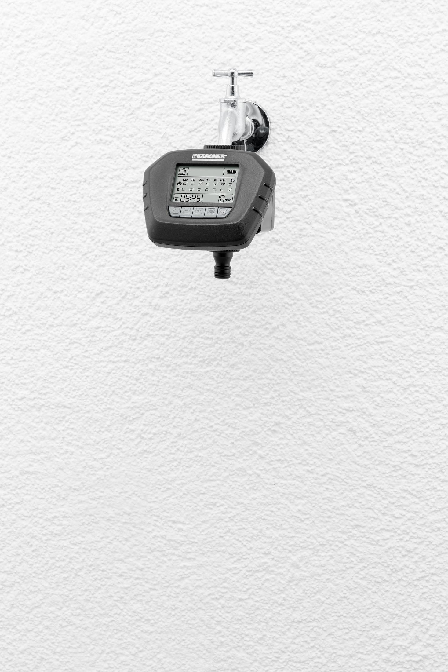 Ein schwarzer und grauer intelligenter Wasserzeitschalter, der an einer weiß strukturierten Wand montiert ist.
