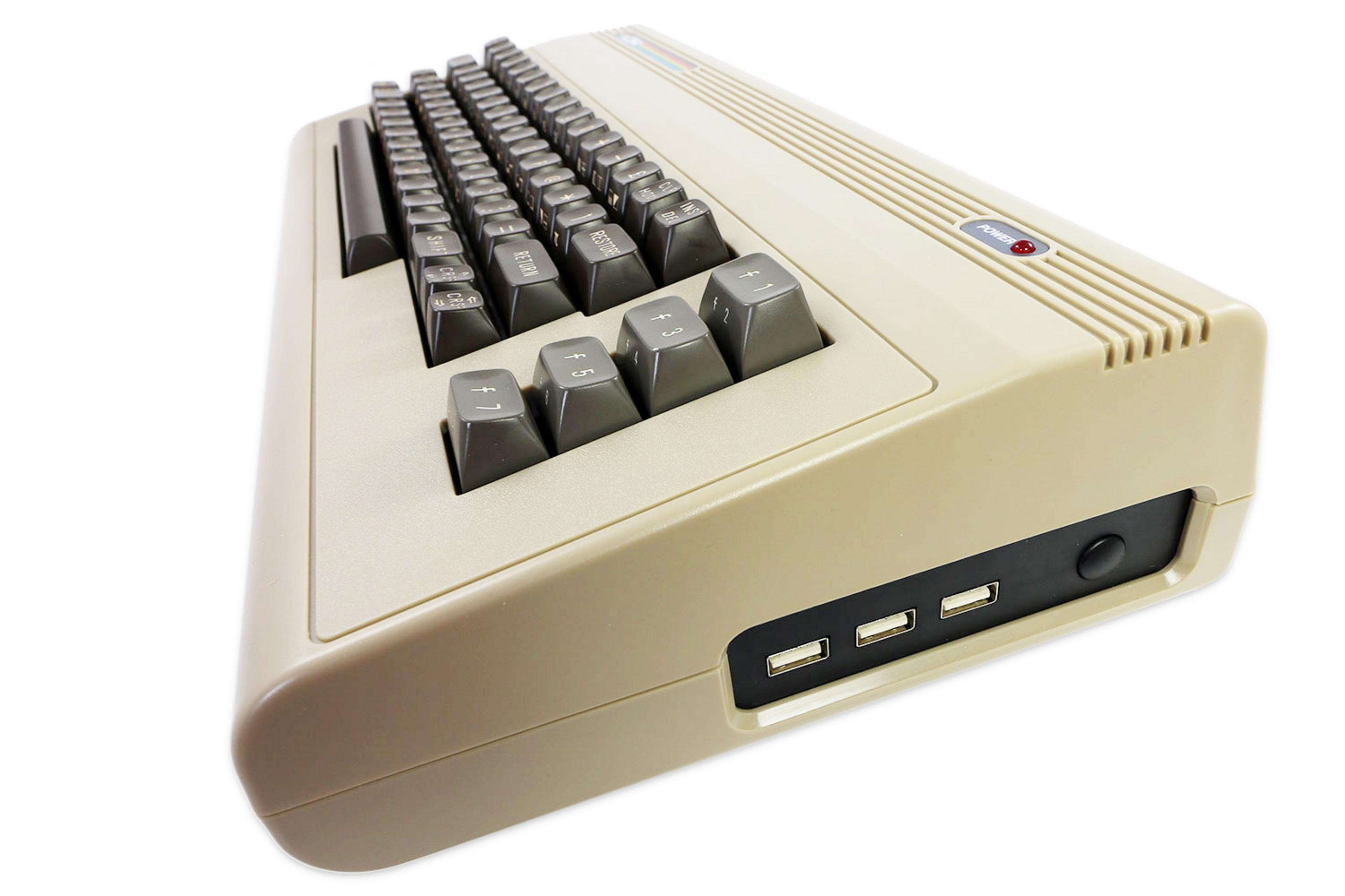 Seitenansicht eines beigen Commodore 64 Computers mit schwarzen Tasten. USB-Anschlüsse sind seitlich sichtbar.