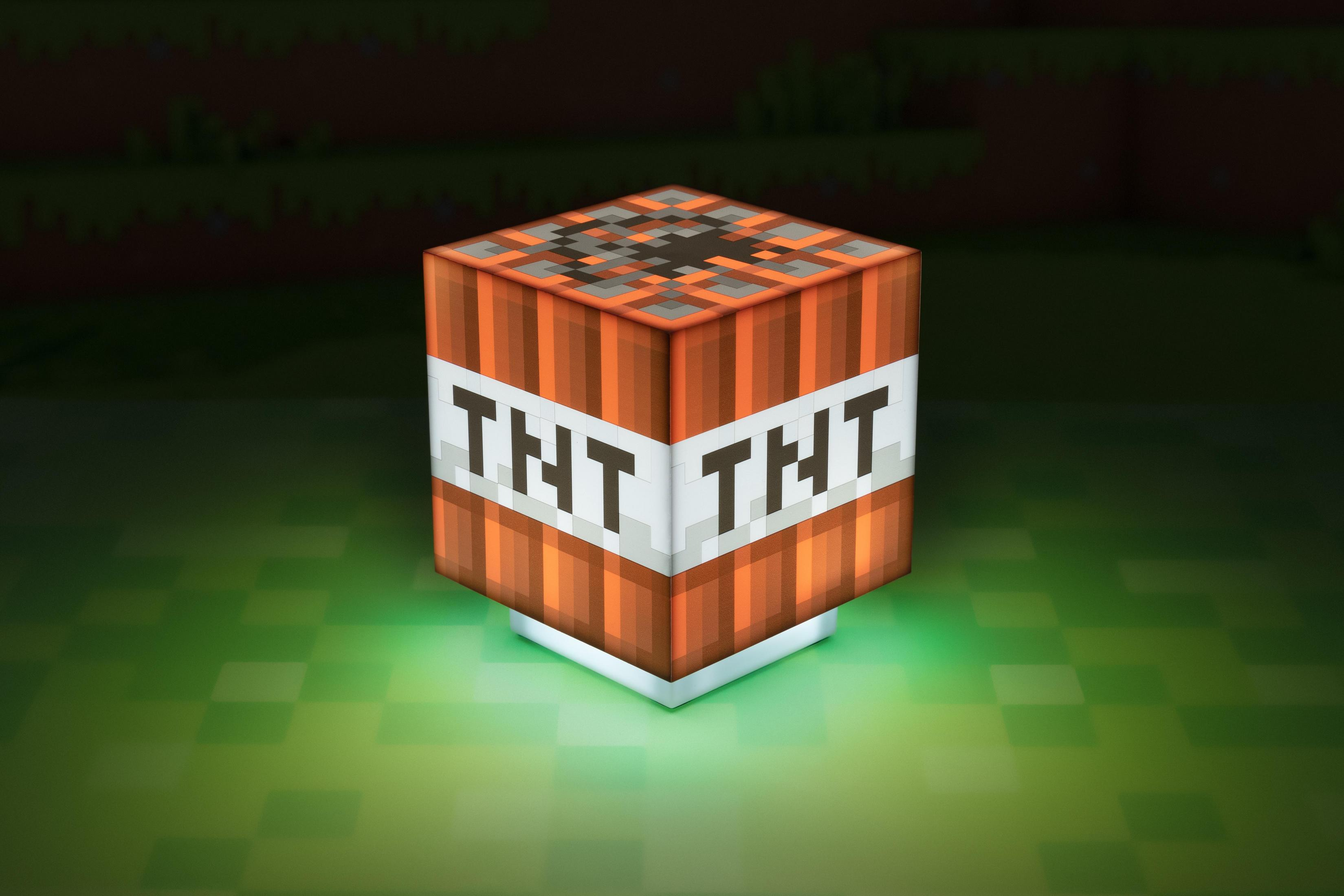 Blok TNT z gry Minecraft jest oświetlony zieloną poświatą, na rozmytym, pikselowanym tle.