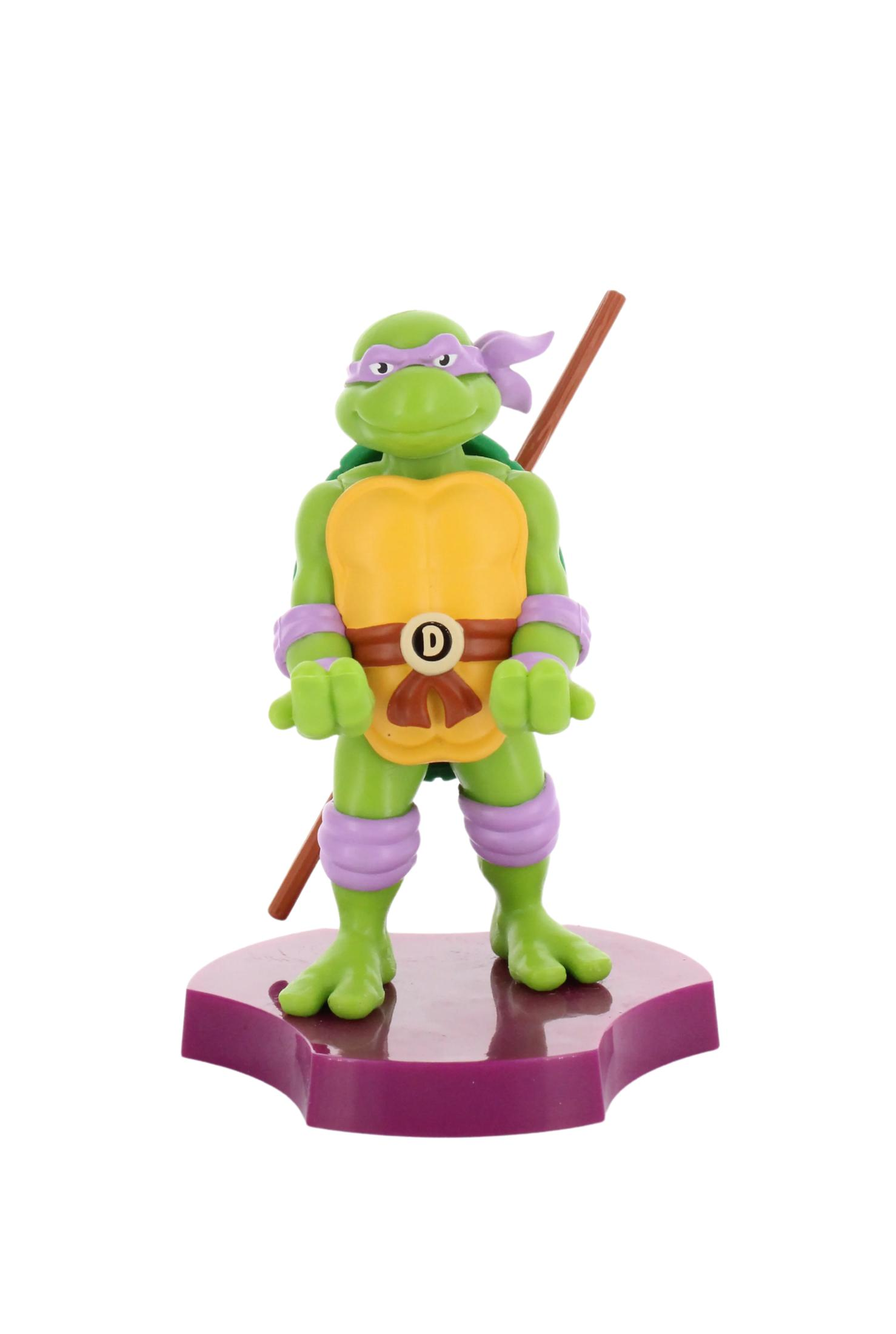 Figurka Donatello. Zielone ciało, fioletowa maska, brązowy kij, na fioletowej podstawie.