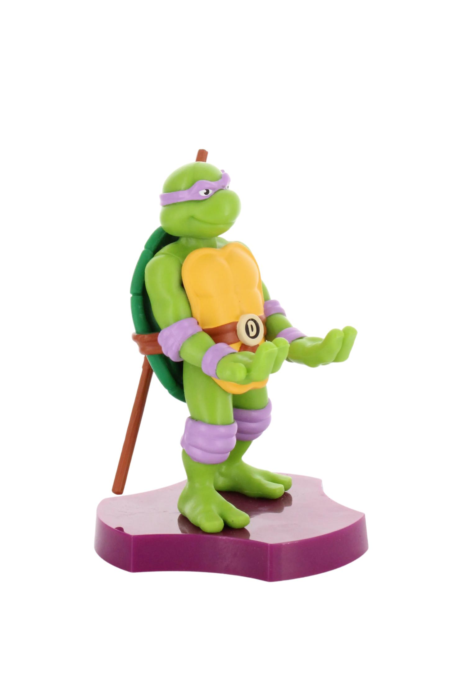 Figurka Donatello z Wojowniczych Żółwi Ninja stojąca na fioletowej podstawie.