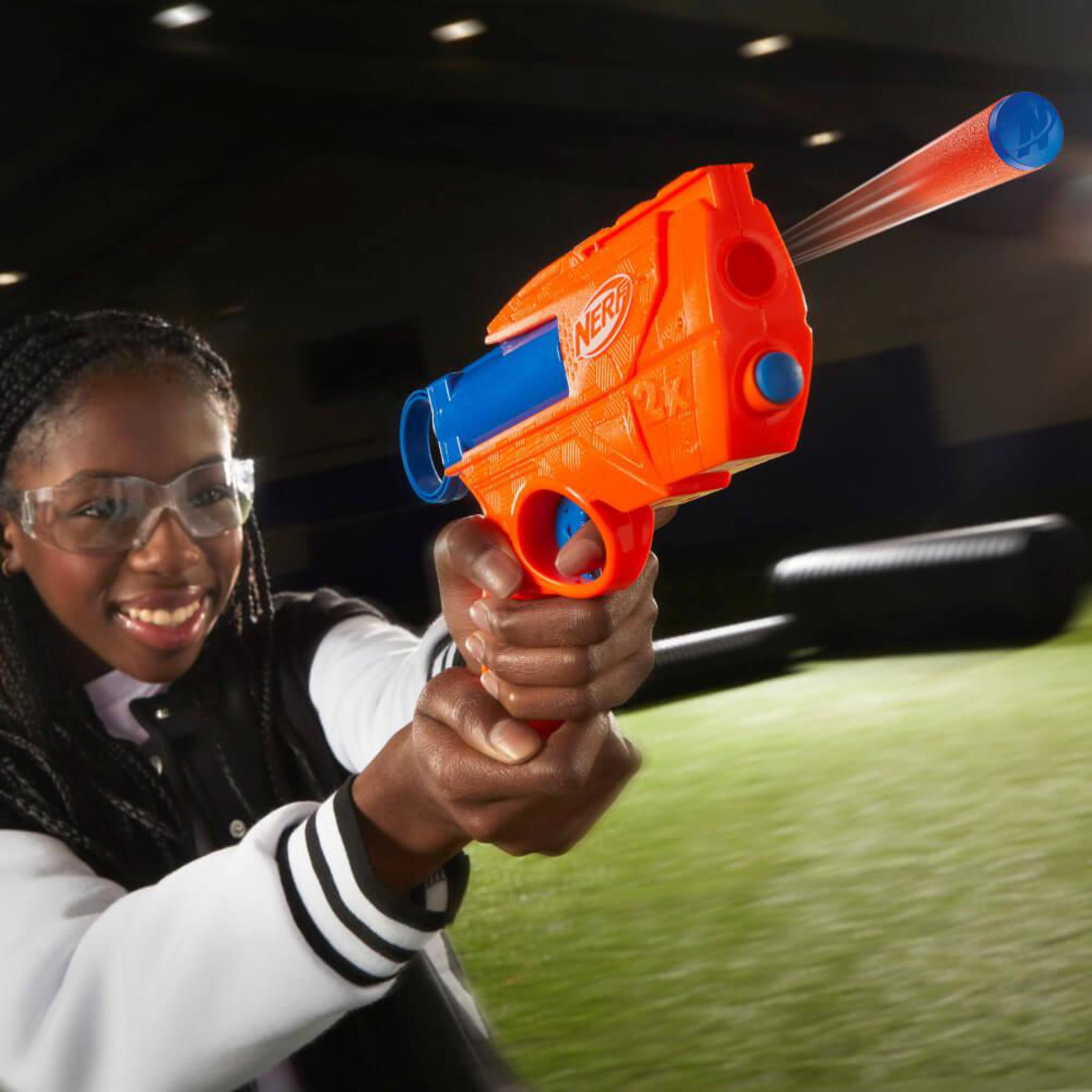 Dziecko w okularach ochronnych celuje pomarańczowo-niebieską bronią Nerf.