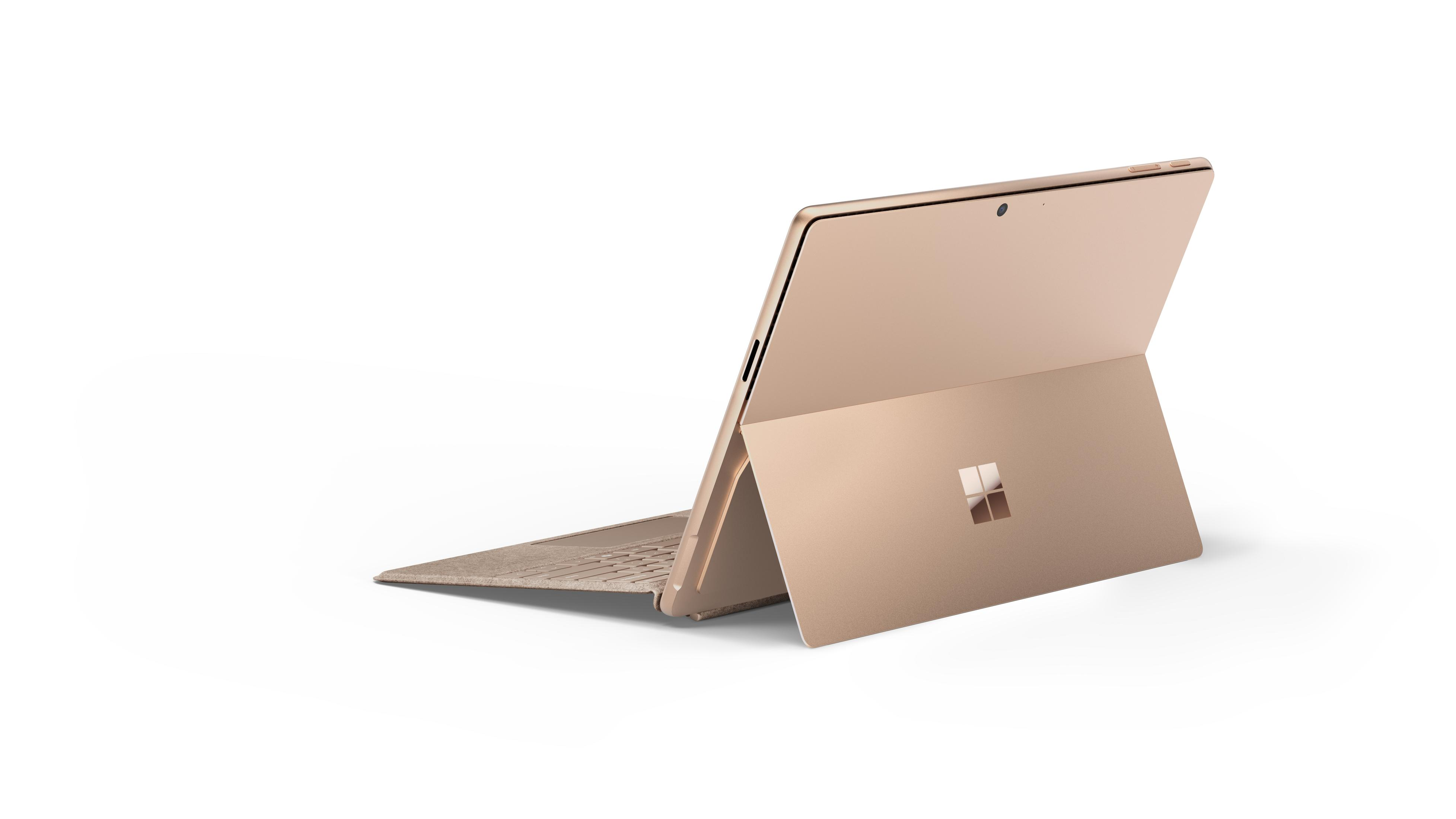 Un laptop dorato con lo schermo aperto, che mostra la tastiera e il retro.