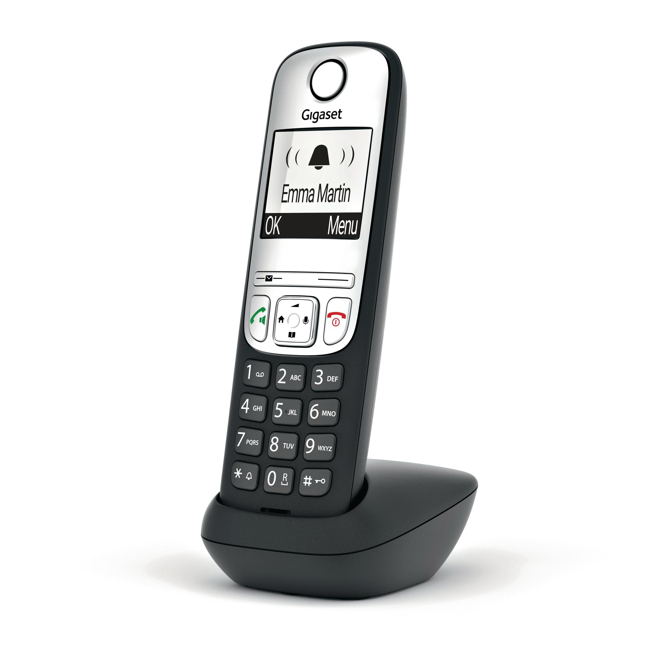 Téléphone Gigaset noir sur une base de chargement. L'écran affiche les options de menu et un nom.