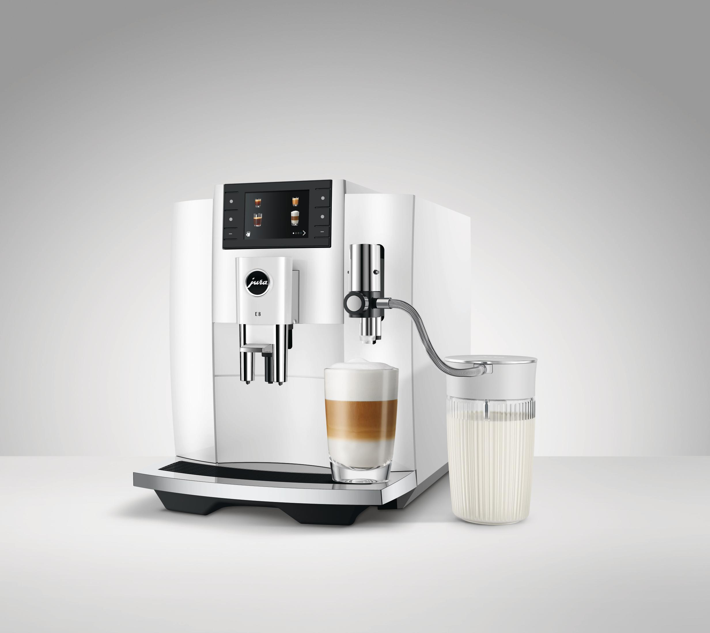 Weiße Kaffeemaschine mit Latte Macchiato-Tasse und Milchbehälter. Hellgrauer Hintergrund.