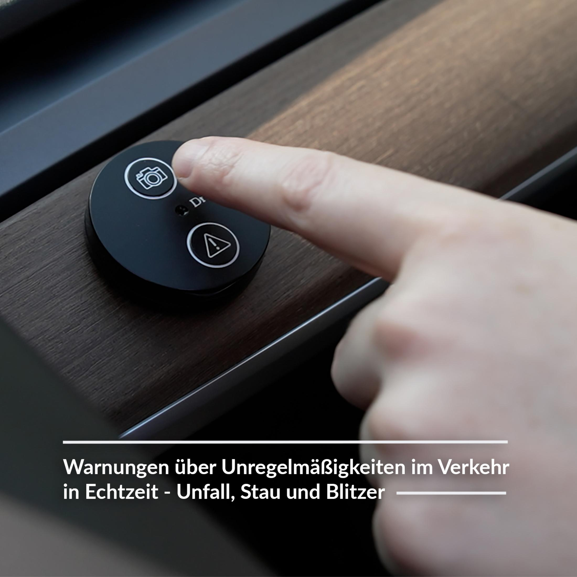 Ein Finger drückt eine Taste mit einem Kamerasymbol. Das Gerät ist schwarz und rund.