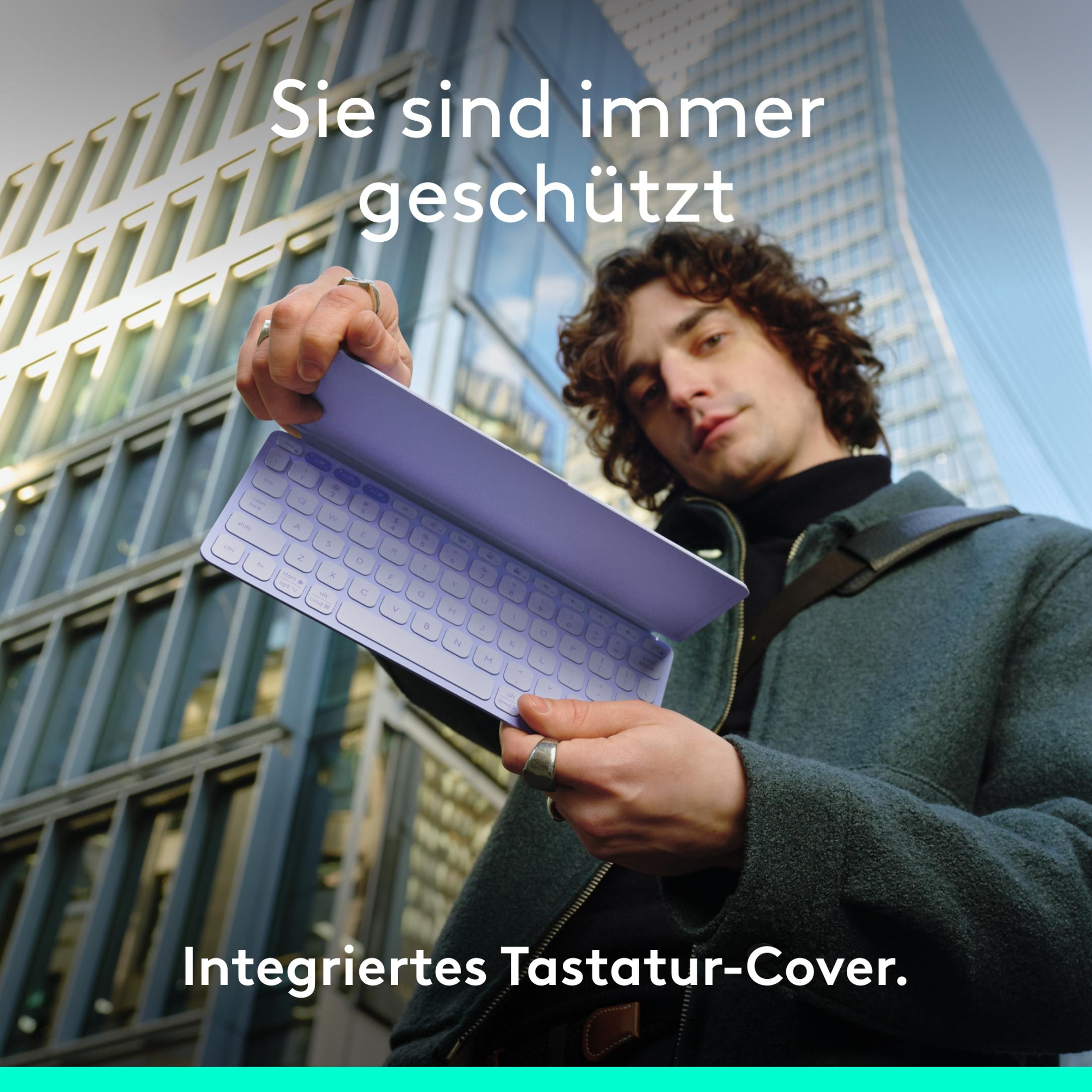 Mann hält eine lila Tastaturabdeckung vor einem Gebäude. Text oben und unten.