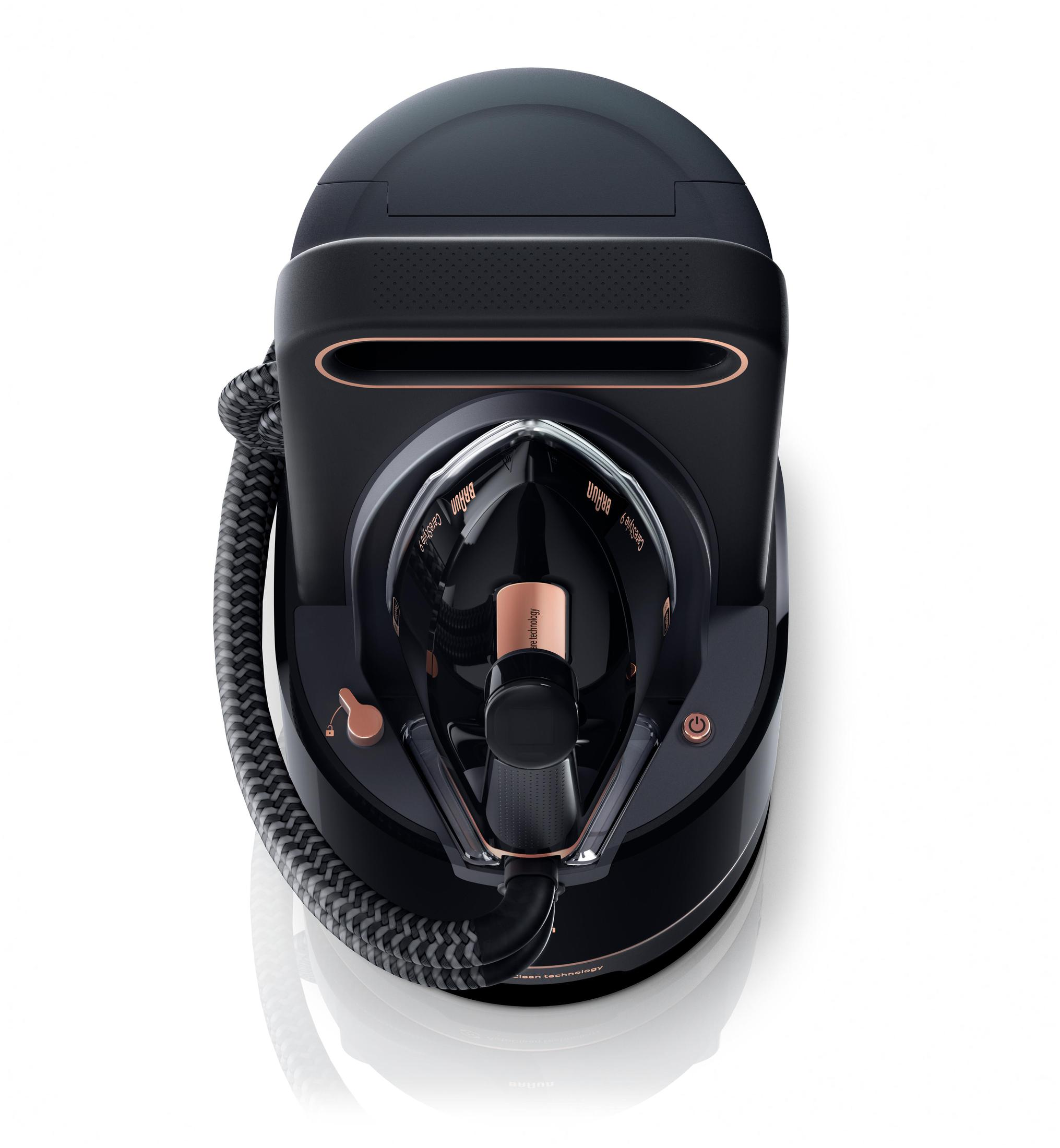 Schwarzes und kupferfarbenes Dampfbügeleisen, Draufsicht, auf weißer Oberfläche. Ein Kabel umwickelt die Basis.