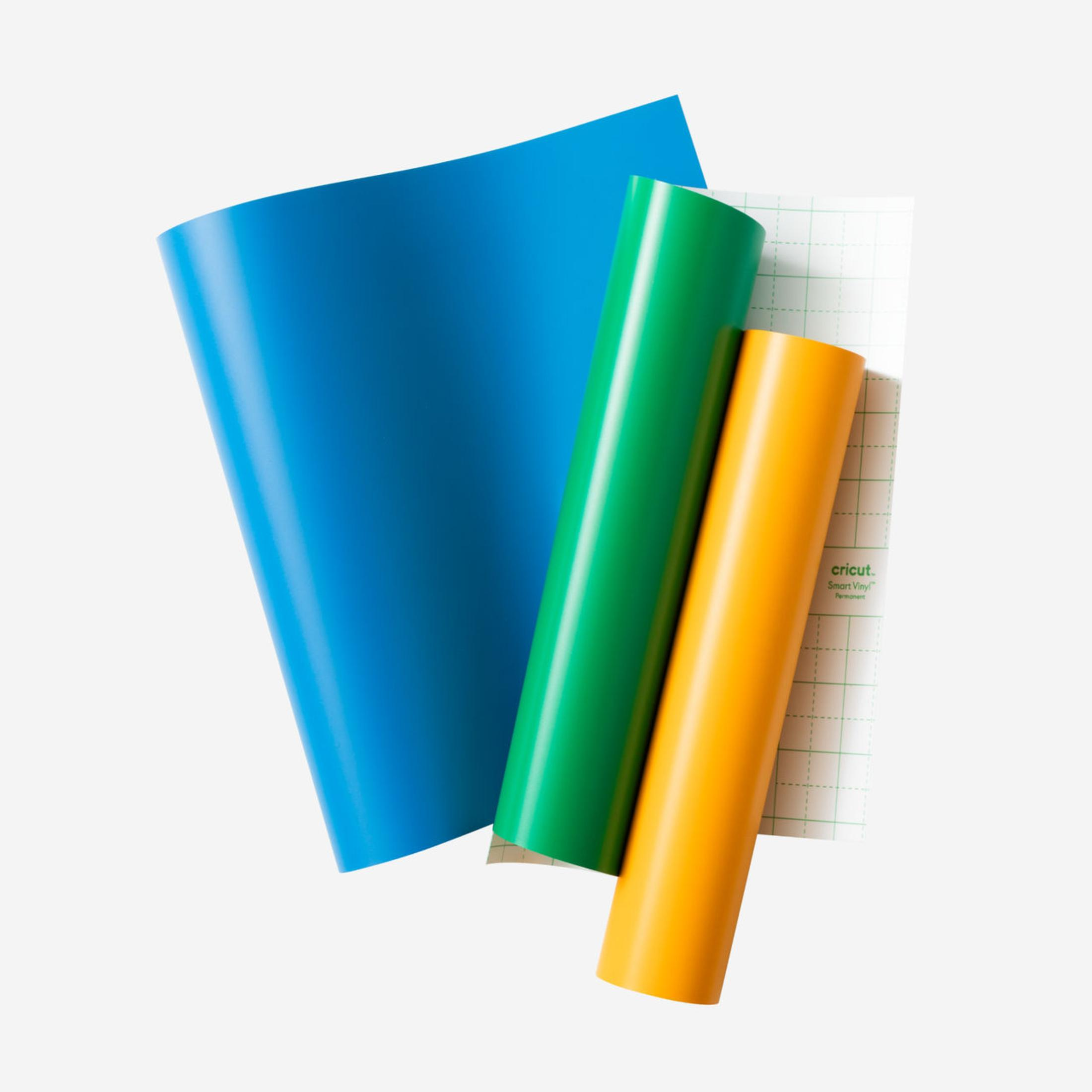 Blaue, grüne und gelbe Vinylbögen und eine Cricut-Schneidematte.