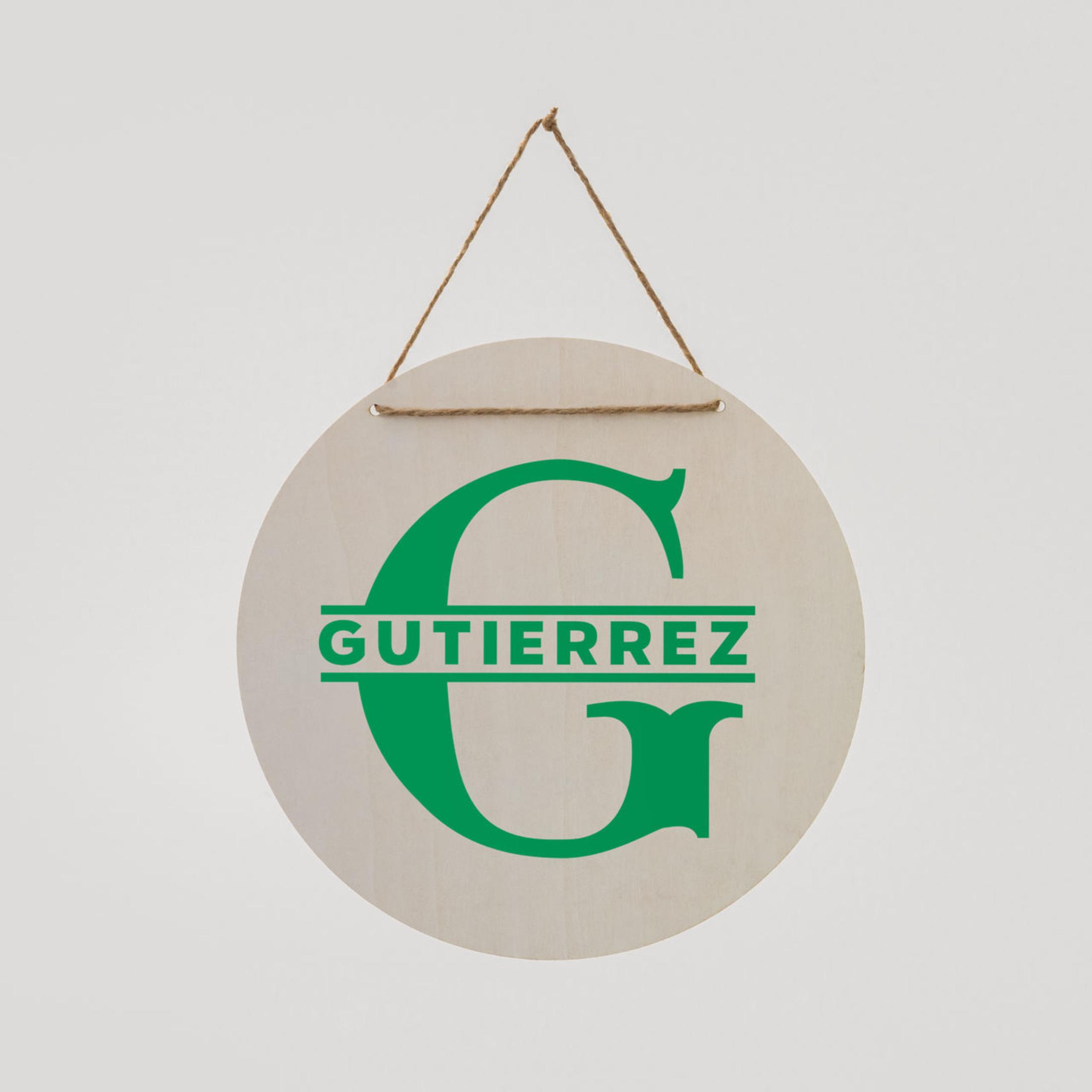 Runder Holzschild mit grünem Buchstaben G und dem Namen Gutierrez.