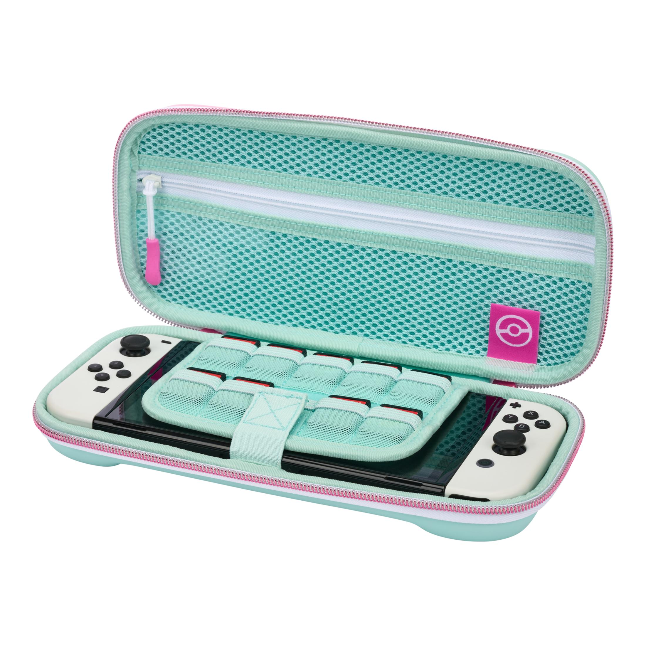 Nintendo Switch w otwartym etui. Konsola i kontrolery w środku, z niebiesko-zielonym wnętrzem. Różowy zamek.