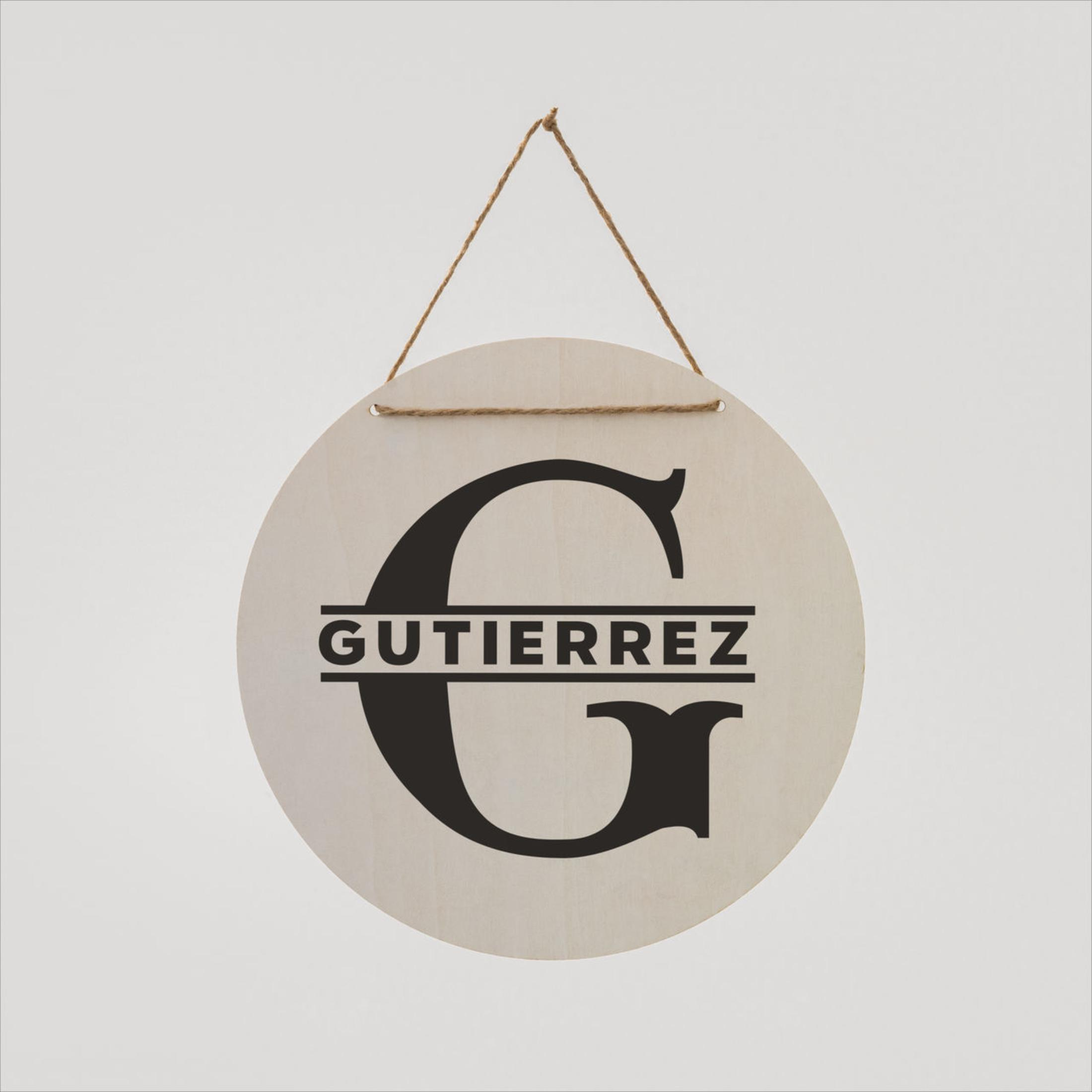 Runder Holzschild mit 'GUTIERREZ' und einem großen Buchstaben 'G'.