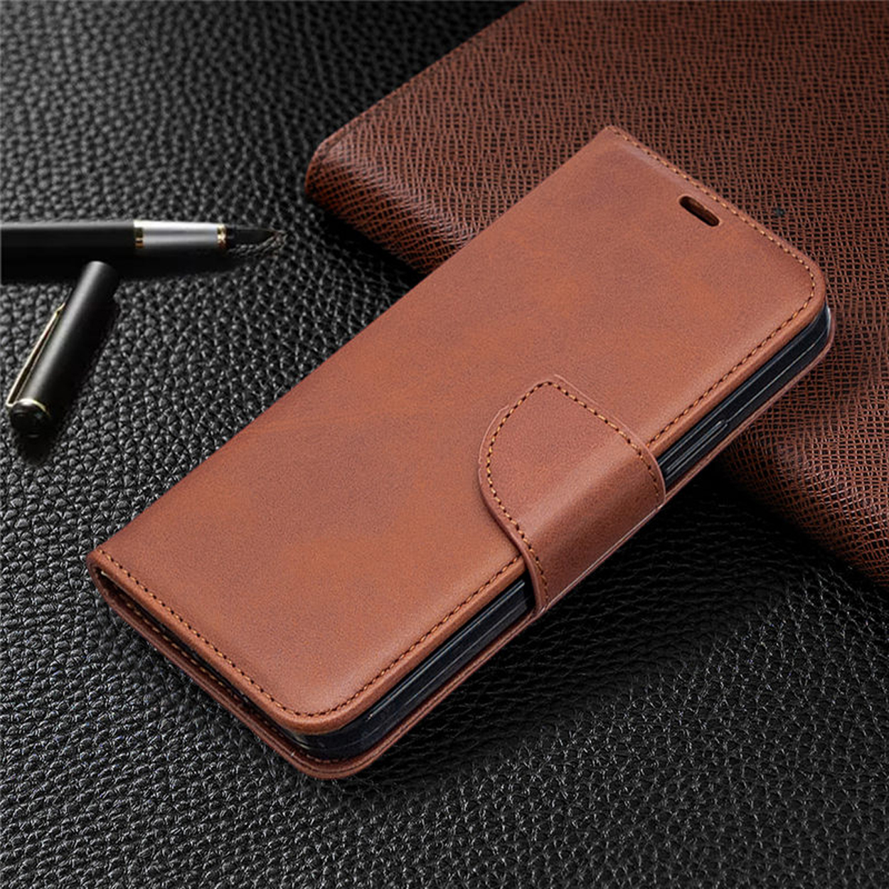 Bruine leren telefoonhoes, gesloten. Met magneetsluiting op een gestructureerd oppervlak.