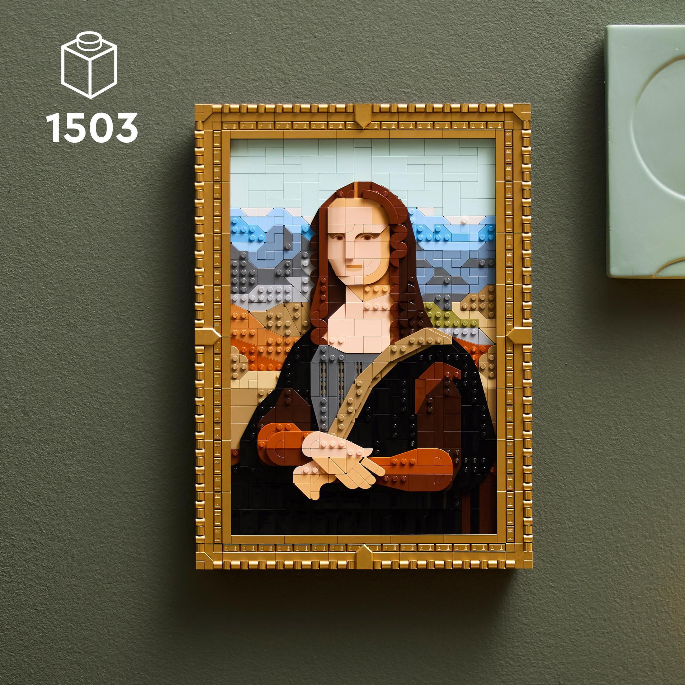 Lego Mona Lisy w złotej ramie, na zielonej ścianie, z pudełkiem w lewym górnym rogu.