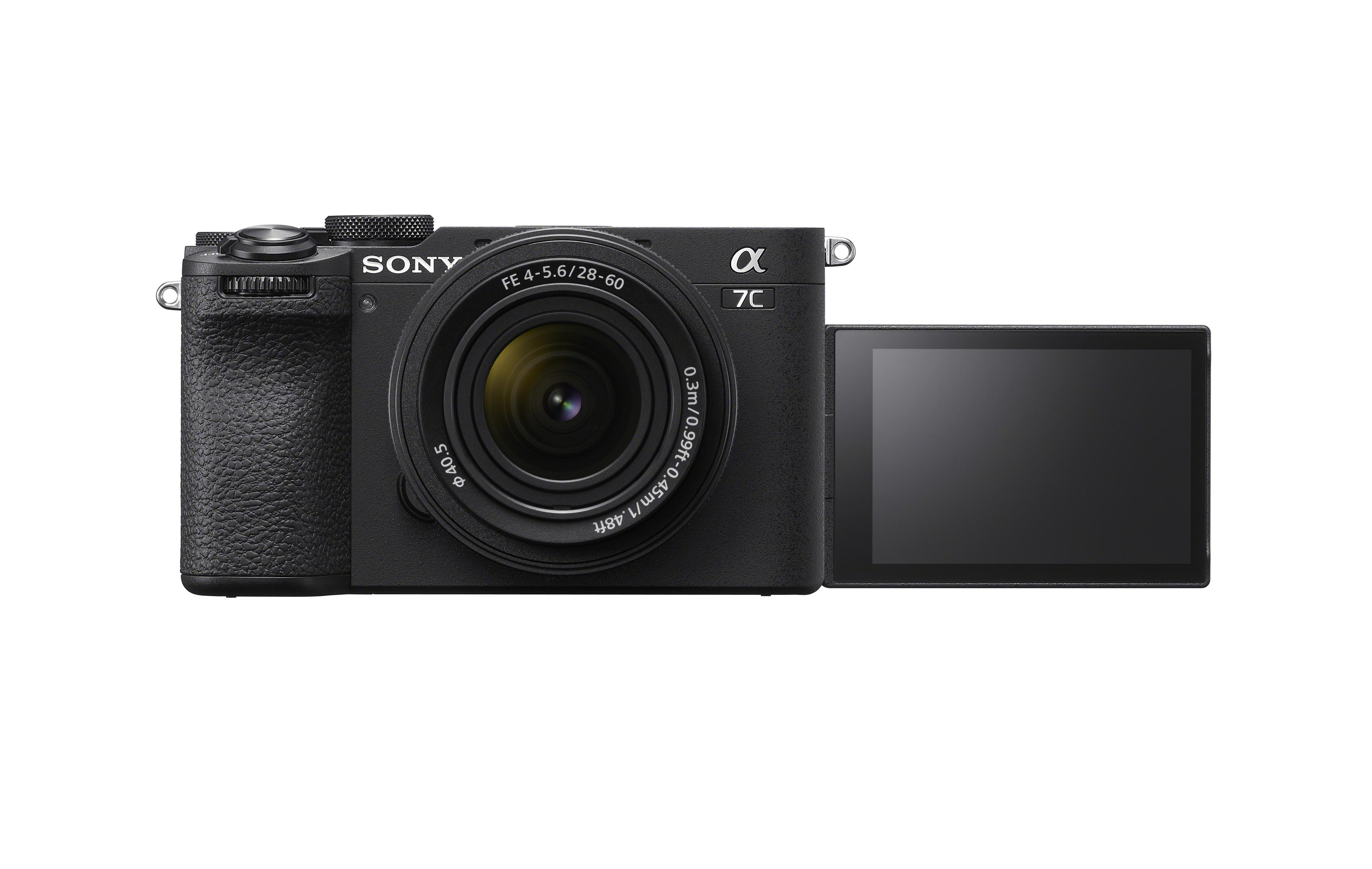 Schwarze Sony-Kamera mit Objektiv und offenem Bildschirm. Der Bildschirm zeigt ein dunkles Bild. Kamera auf weißer Oberfläche.