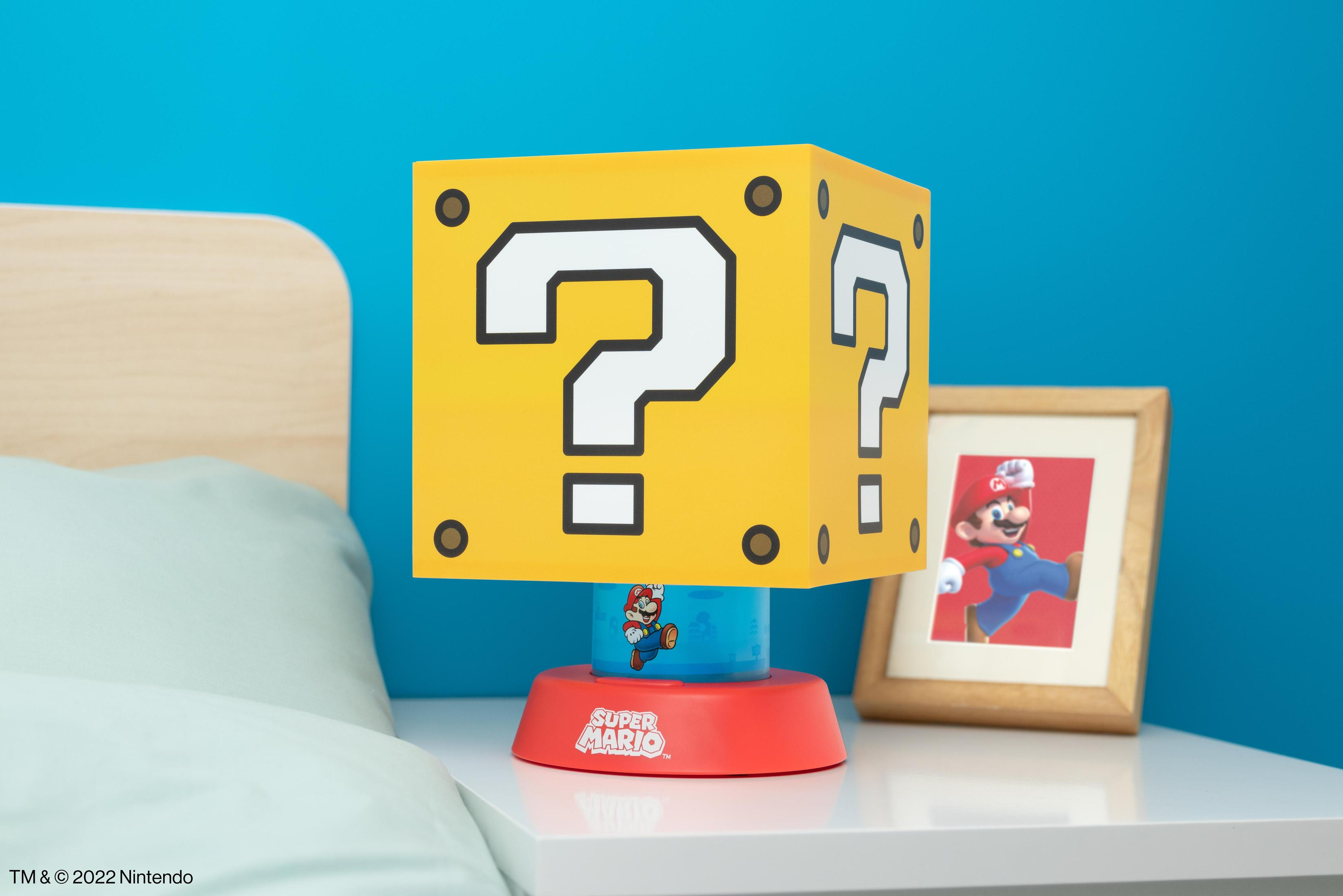 Lampa z motywem Super Mario przed łóżkiem, obok oprawionego zdjęcia Mario.