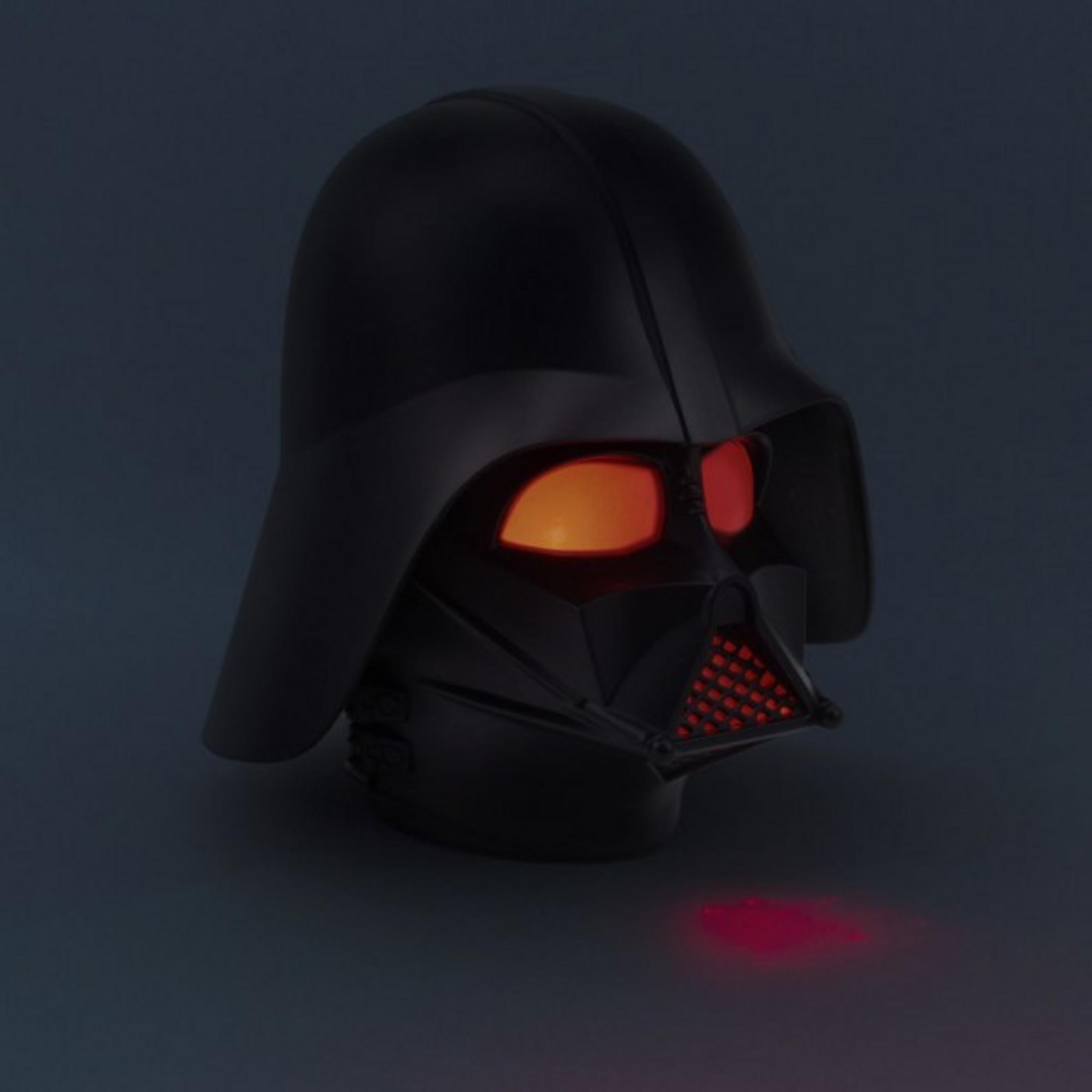 Hełm Darth Vadera z świecącymi czerwonymi oczami na ciemnym tle.