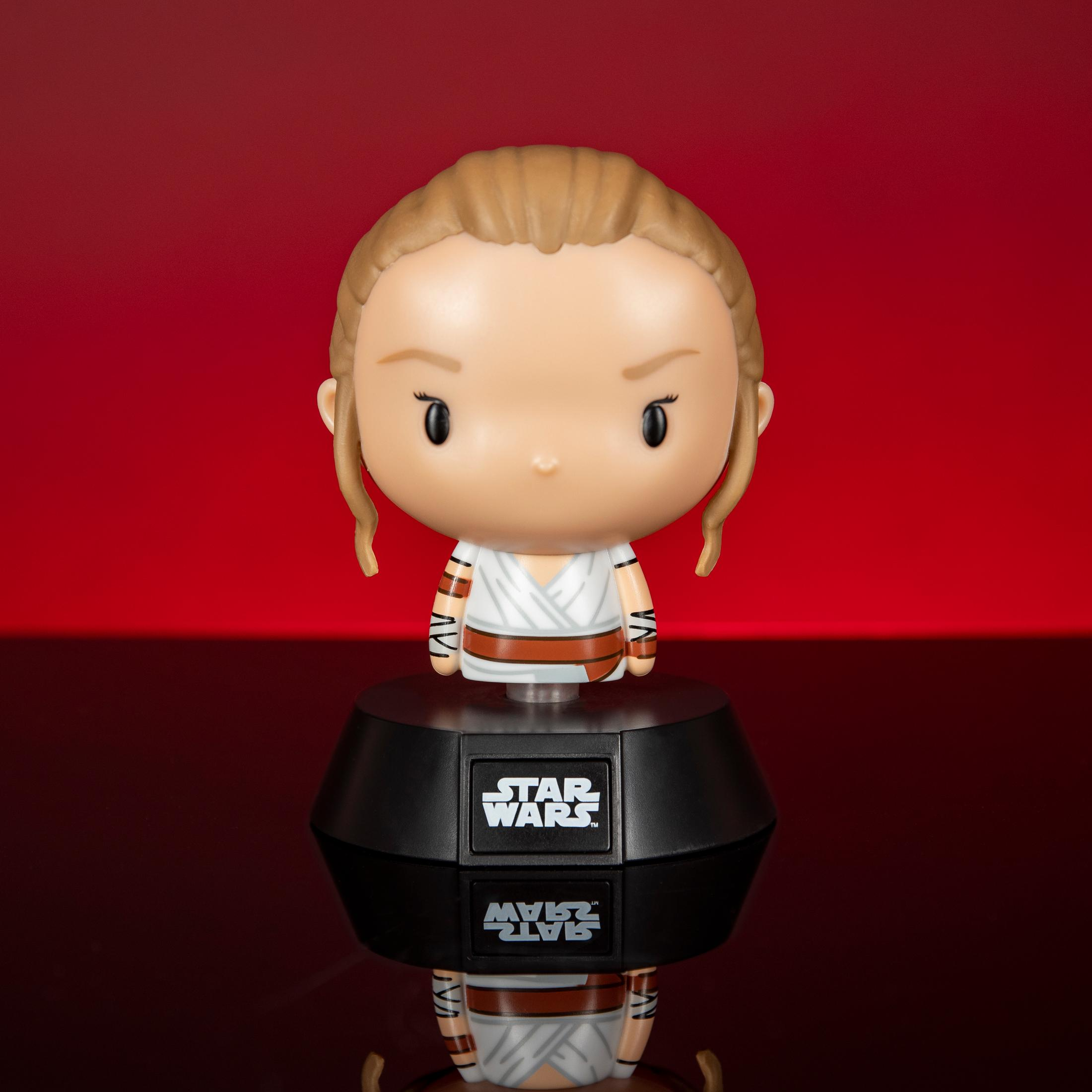 Una figura de Rey de Star Wars con cabeza oscilante sobre un soporte negro sobre fondo rojo.