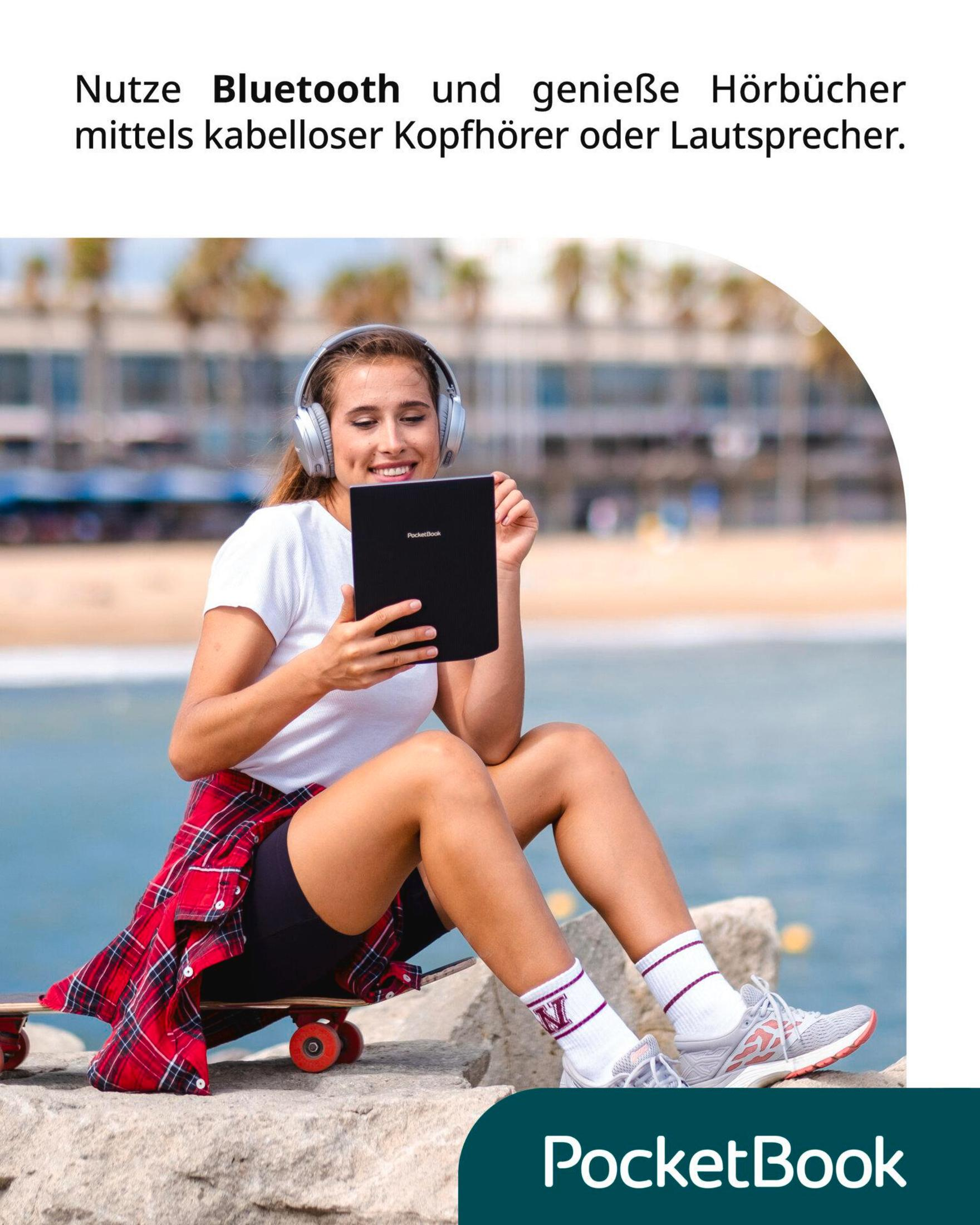 Kobieta siedzi na kamieniu, ma słuchawki i trzyma tablet. Widoczny jest tekst 'PocketBook'.