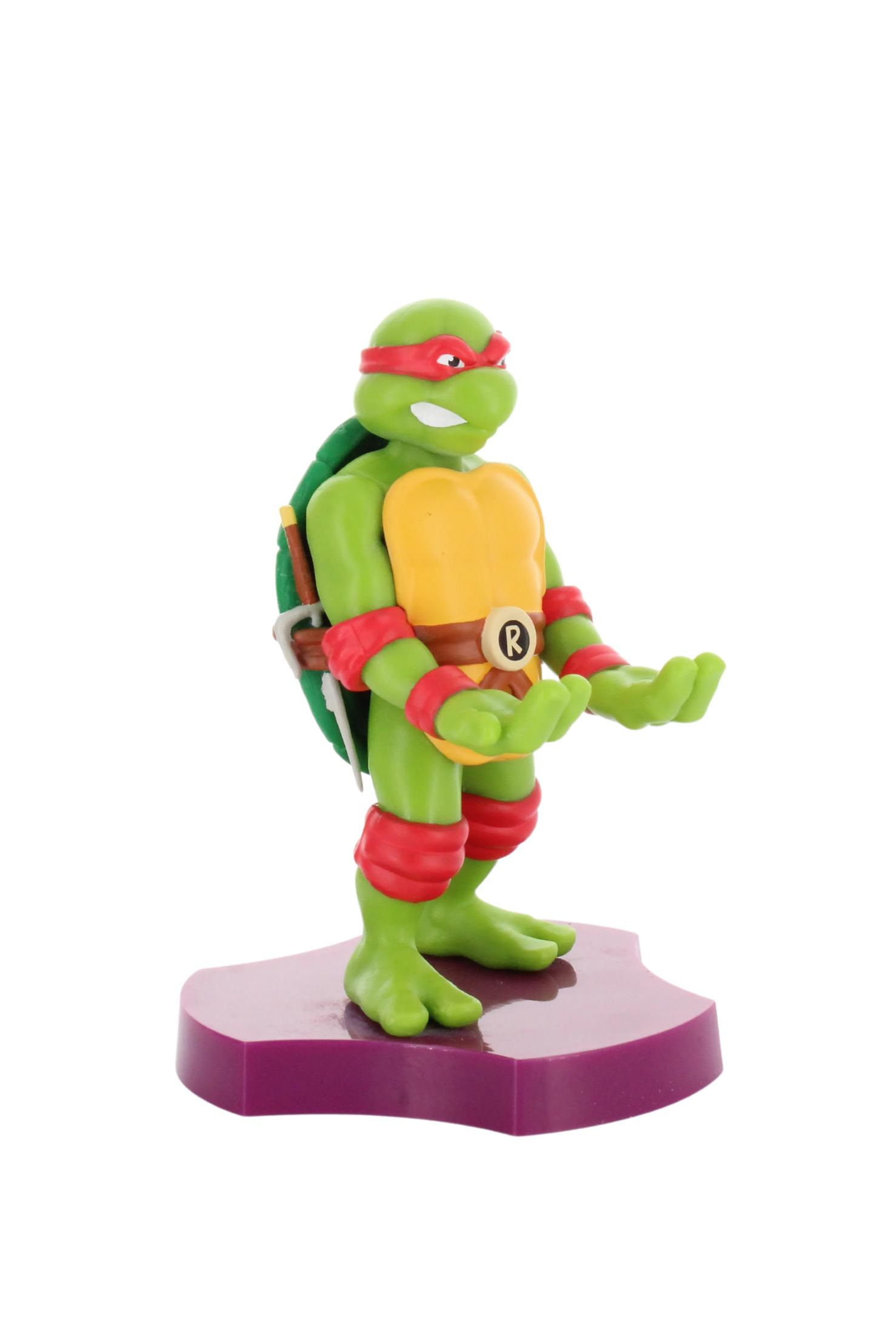 Una statuina di Tartaruga Ninja, Raffaello, su base viola. Figura verde, maschera rossa.