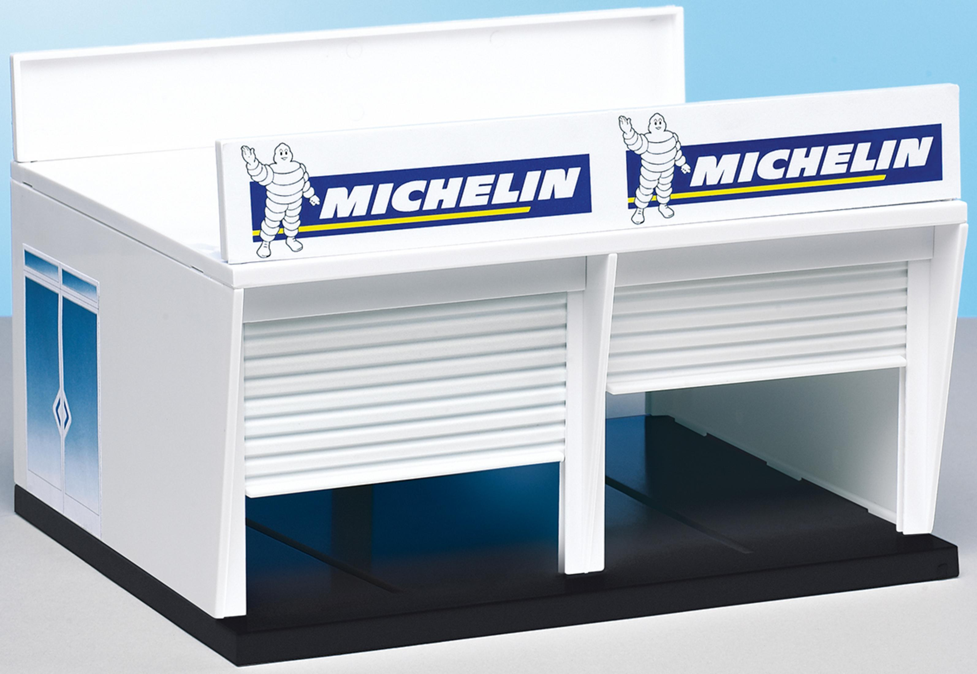 Ein weißes Michelin-Spielzeug-Garagengebäude mit zwei geschlossenen Rollläden. Das Logo ist oben.