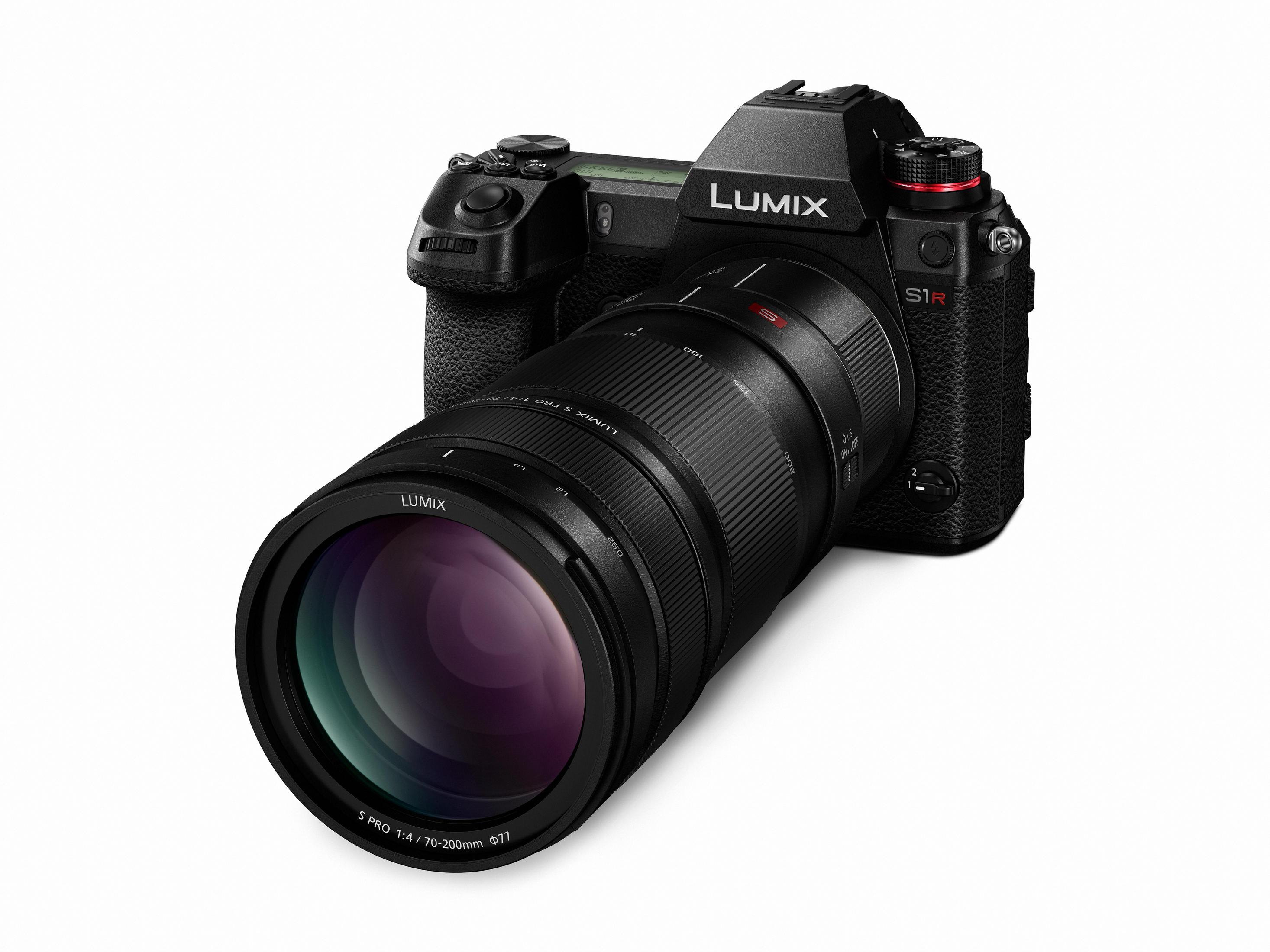 Schwarze Lumix S1R Kamera mit großem Objektiv, vor weißem Hintergrund.
