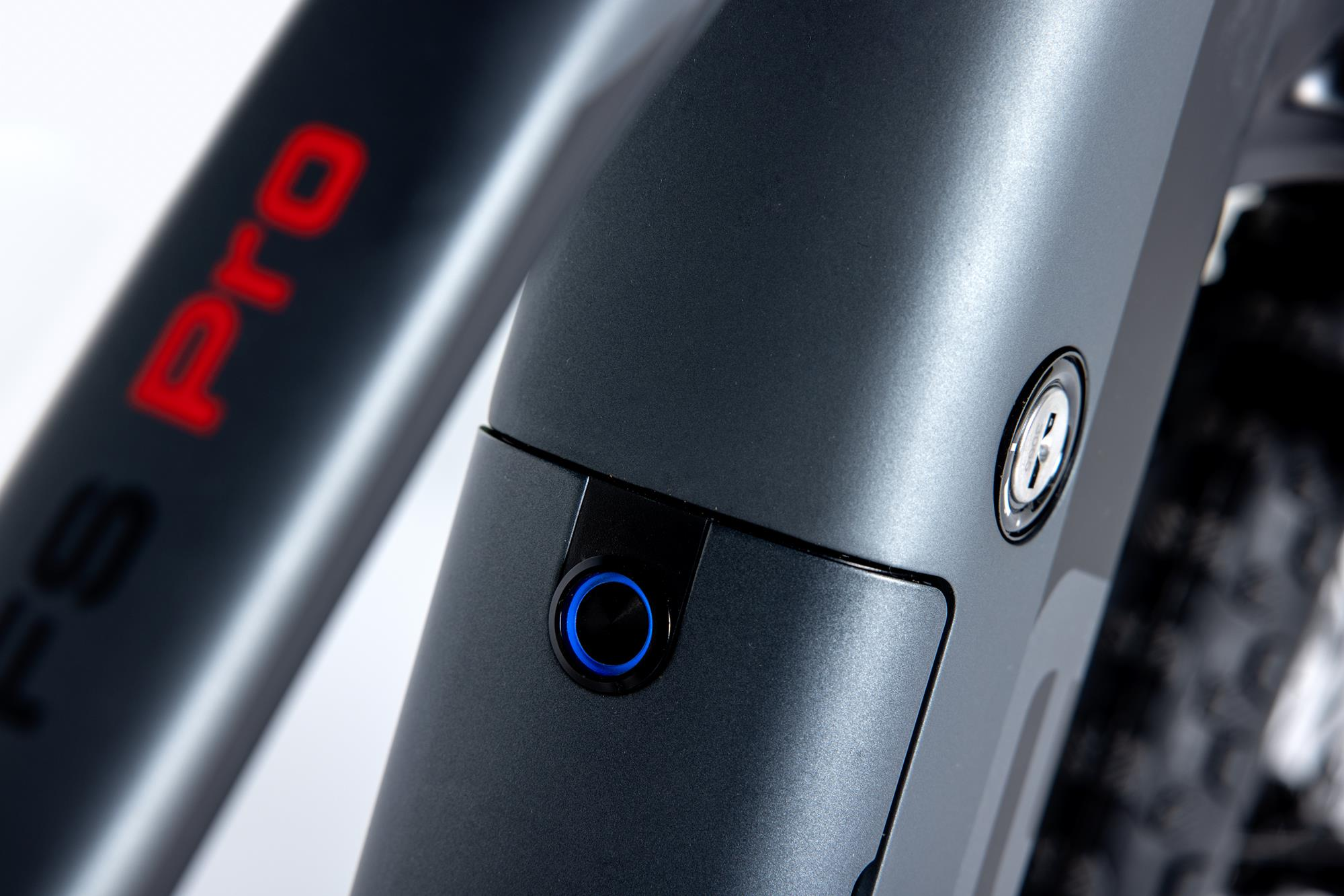 Nahaufnahme eines schwarzen E-Bike-Rahmens mit rotem FS Pro-Text. Ein blauer Knopf ist sichtbar.