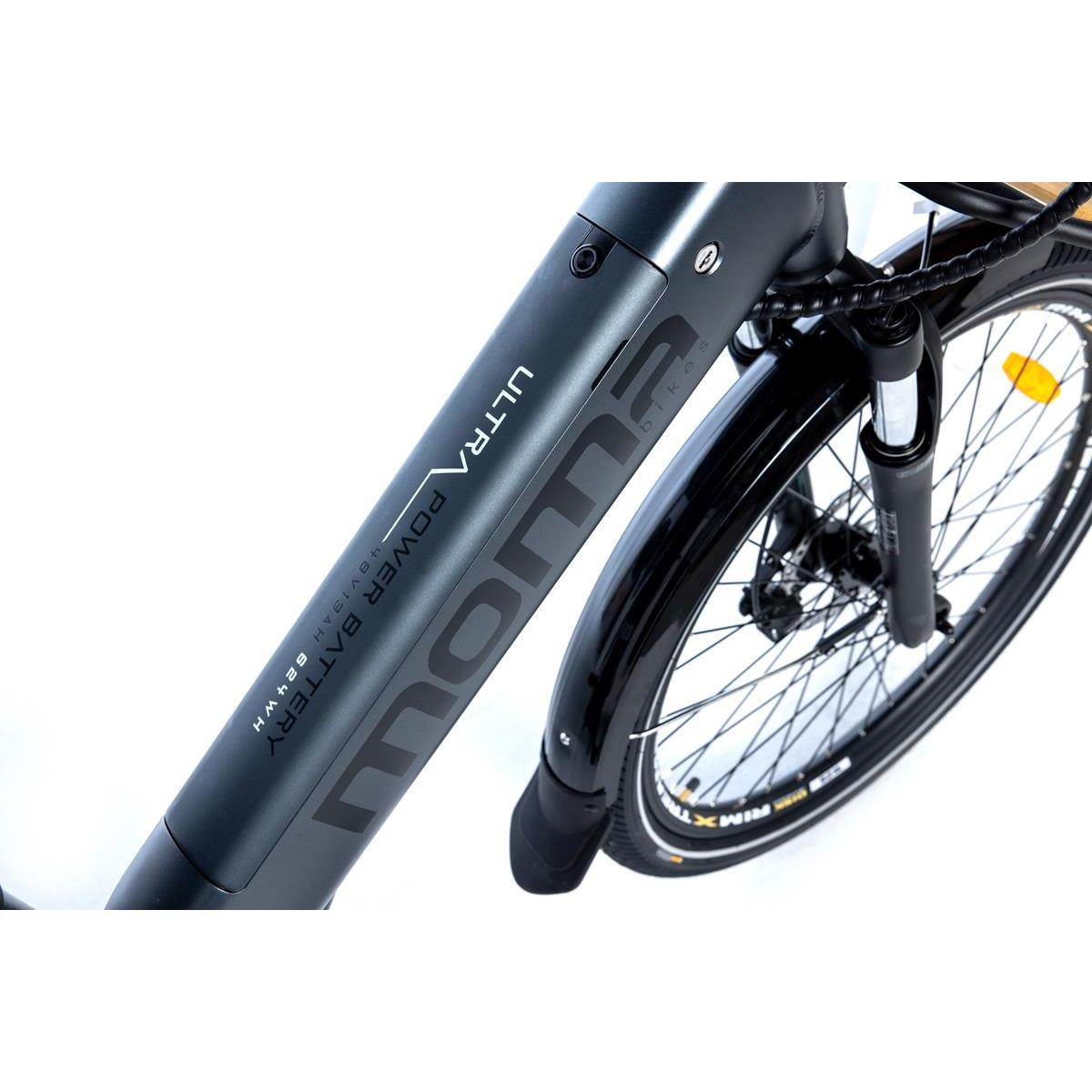 Ein Elektrofahrrad. Schwarzer Rahmen mit 'Moma'-Logo. Vorderrad sichtbar.