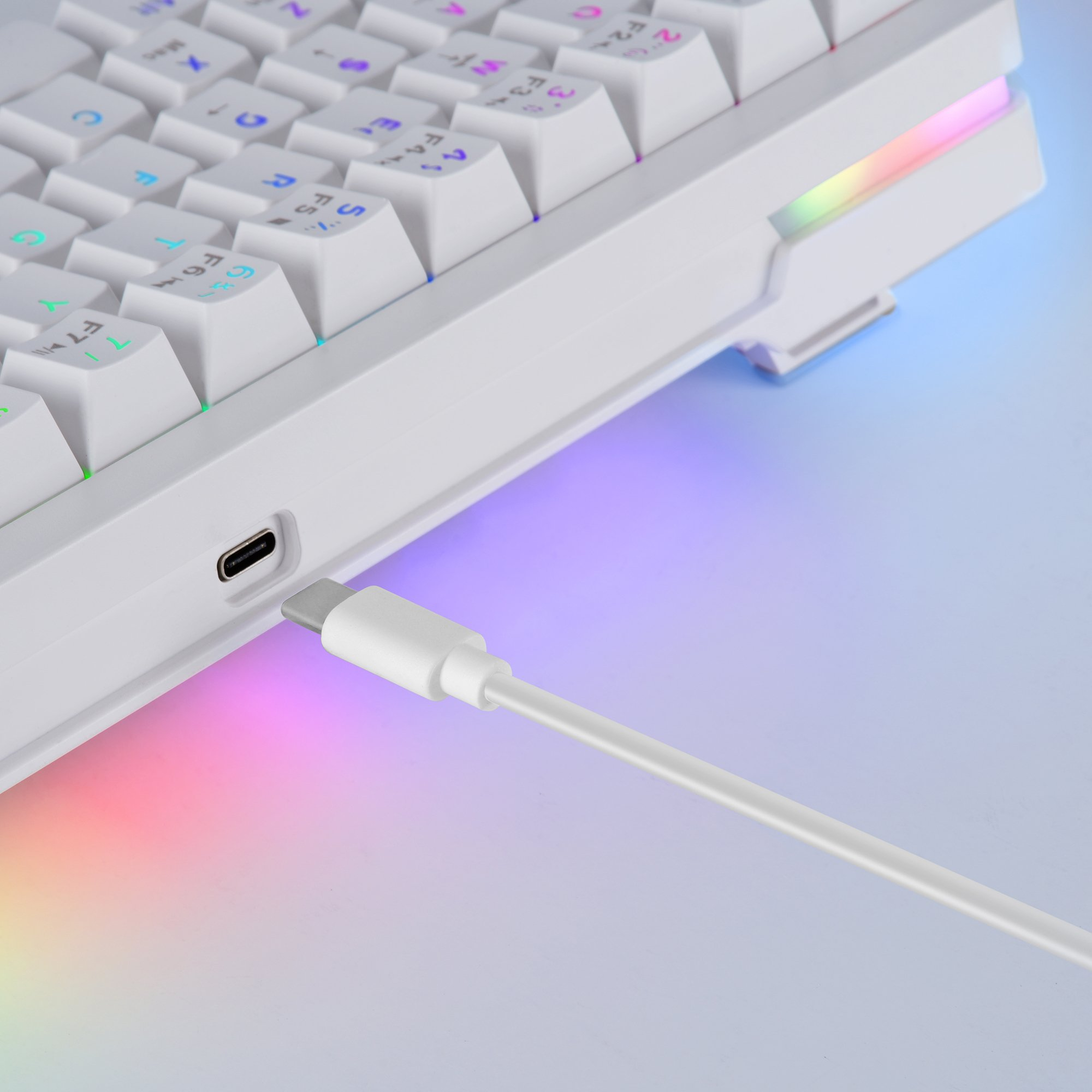 Biała klawiatura z kolorowymi światłami i białym kablem USB-C. Klawisze są białe z japońskimi i angielskimi znakami.