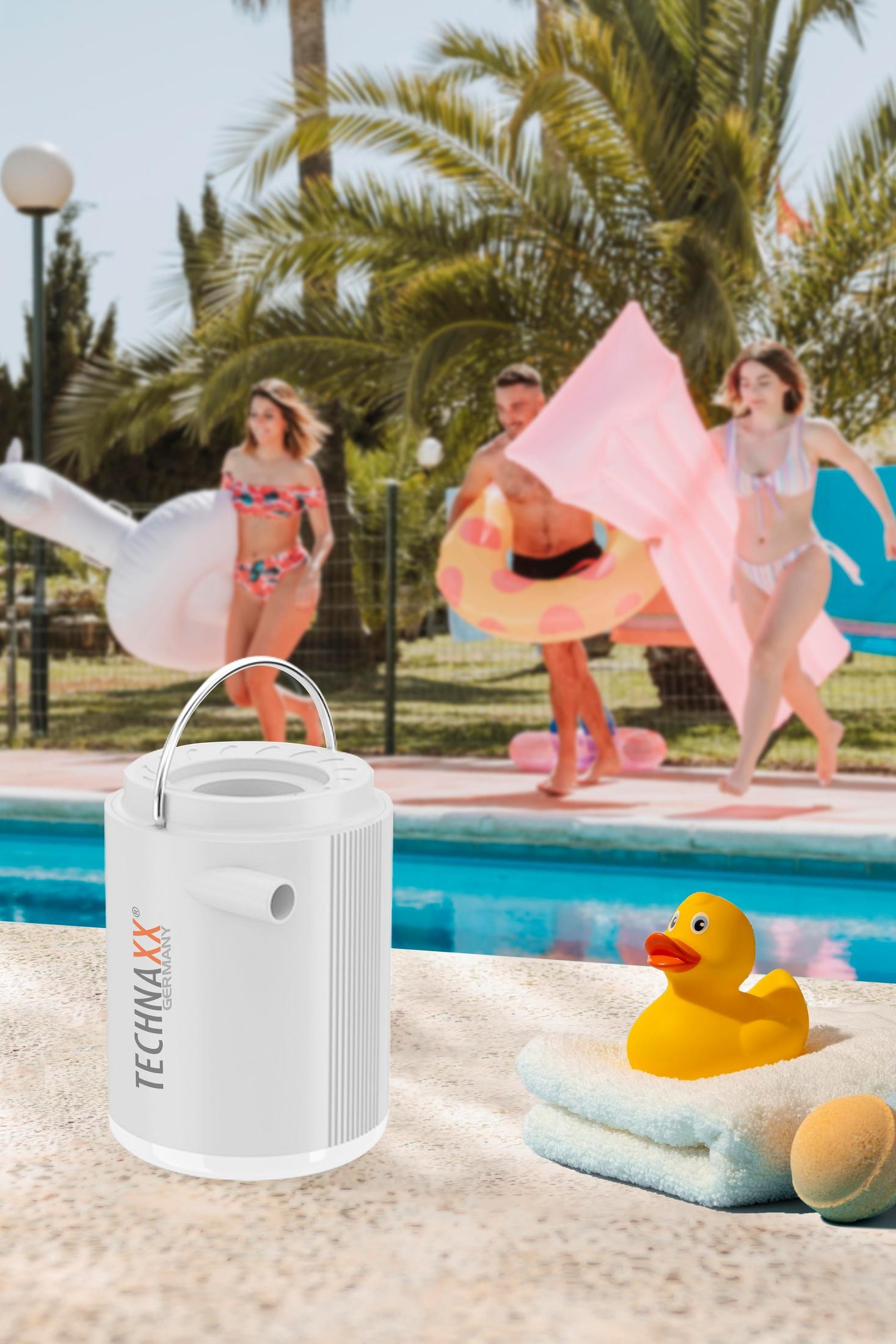 Weißes TECHNAXX Germany-Gerät neben einem Pool mit einer Ente, Handtüchern und Personen im Hintergrund.