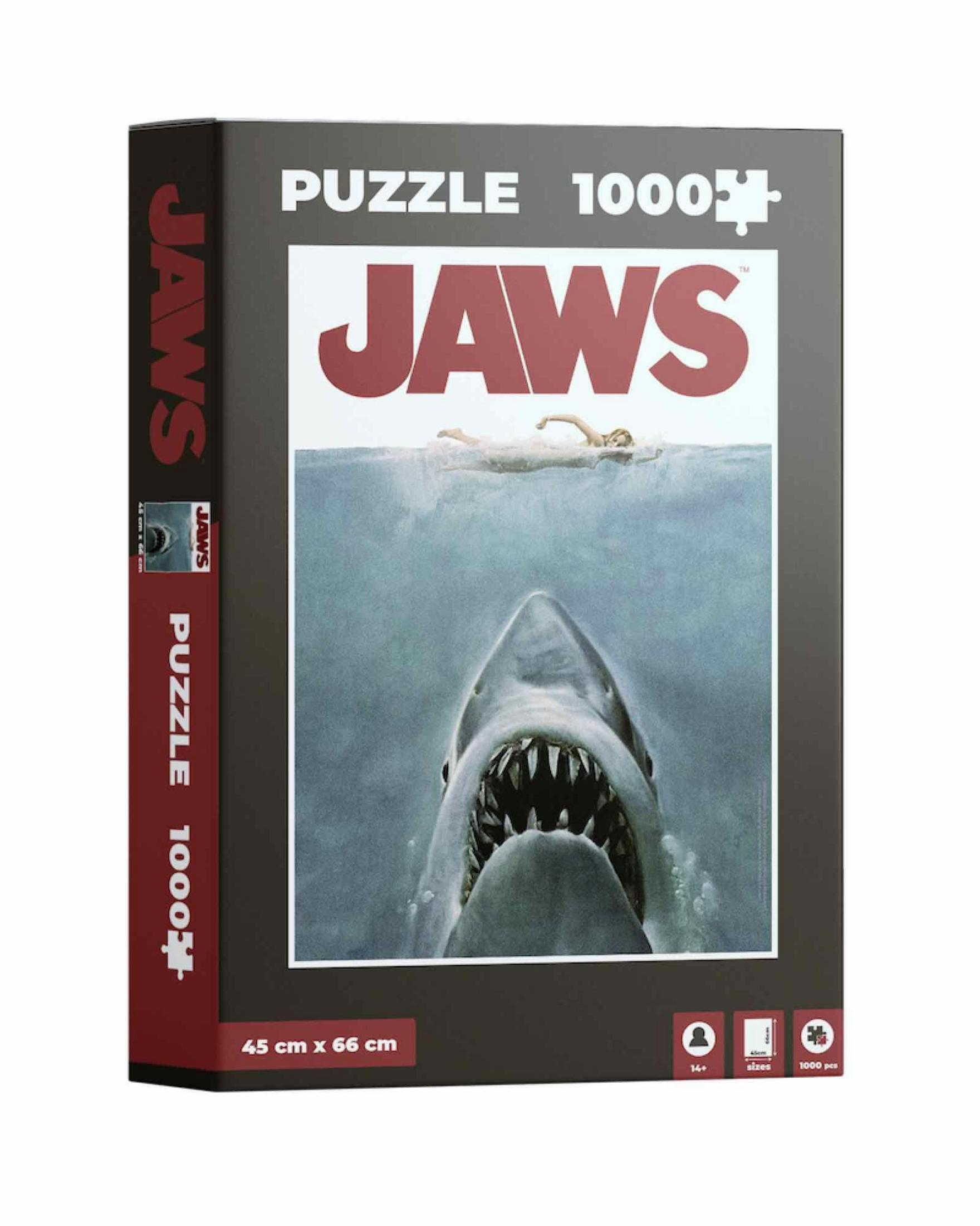Eine Jaws 1000-teilige Puzzlebox, die einen Hai zeigt, der einen Schwimmer angreift. Die Box ist schwarz und rot.