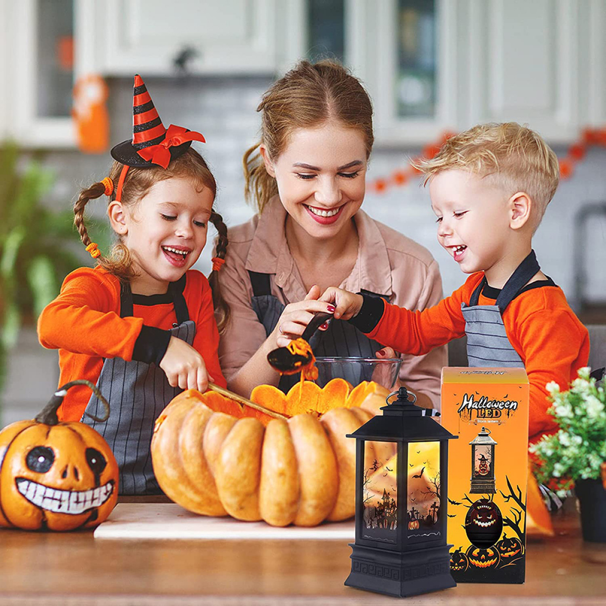 Familie schnitzt gemeinsam einen Kürbis. Eine Halloween-Laterne steht auf dem Tisch und ein Kürbis.