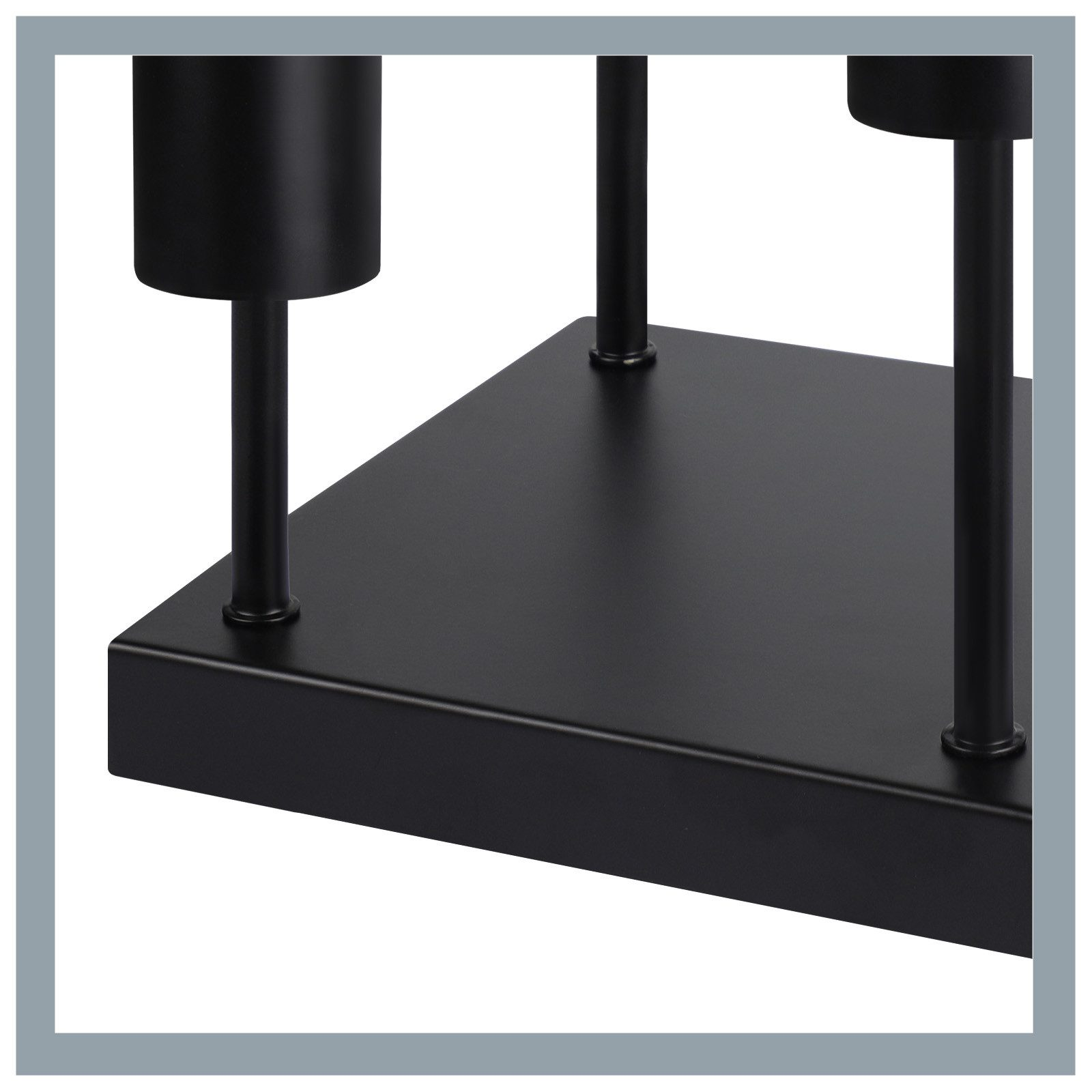 Zbliżenie czarnego metalowego świecznika z dwoma uchwytami na świece. Podstawa jest kwadratowa, a design nowoczesny.