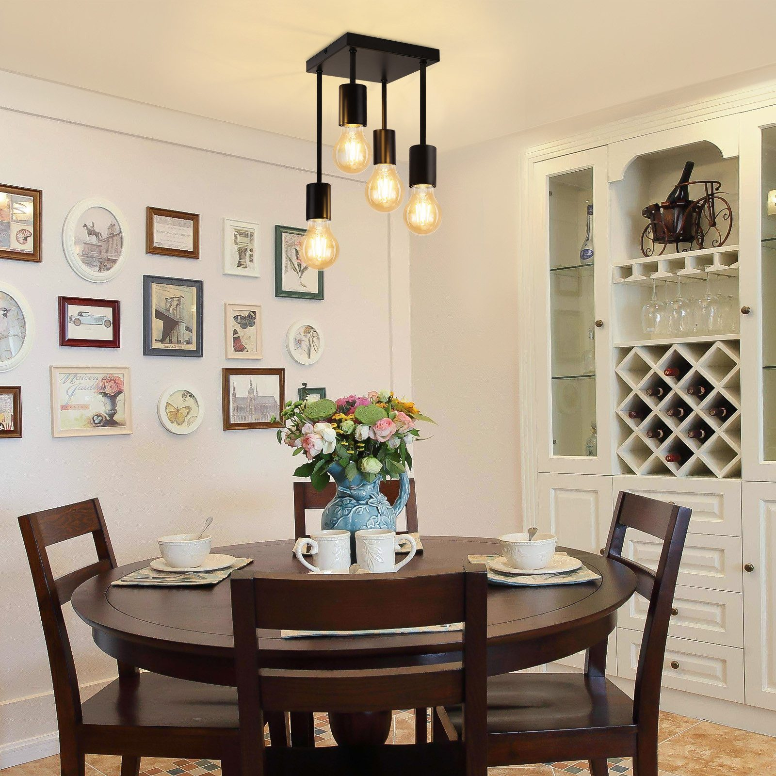 Jadalnia z czarnym żyrandolem. W centrum stół z kwiatami i naczyniami.