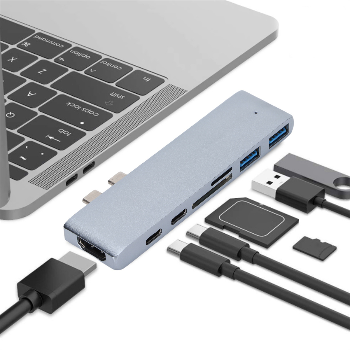 Ein grauer Hub mit mehreren Anschlüssen liegt neben einem Laptop, mit verschiedenen angeschlossenen Geräten.